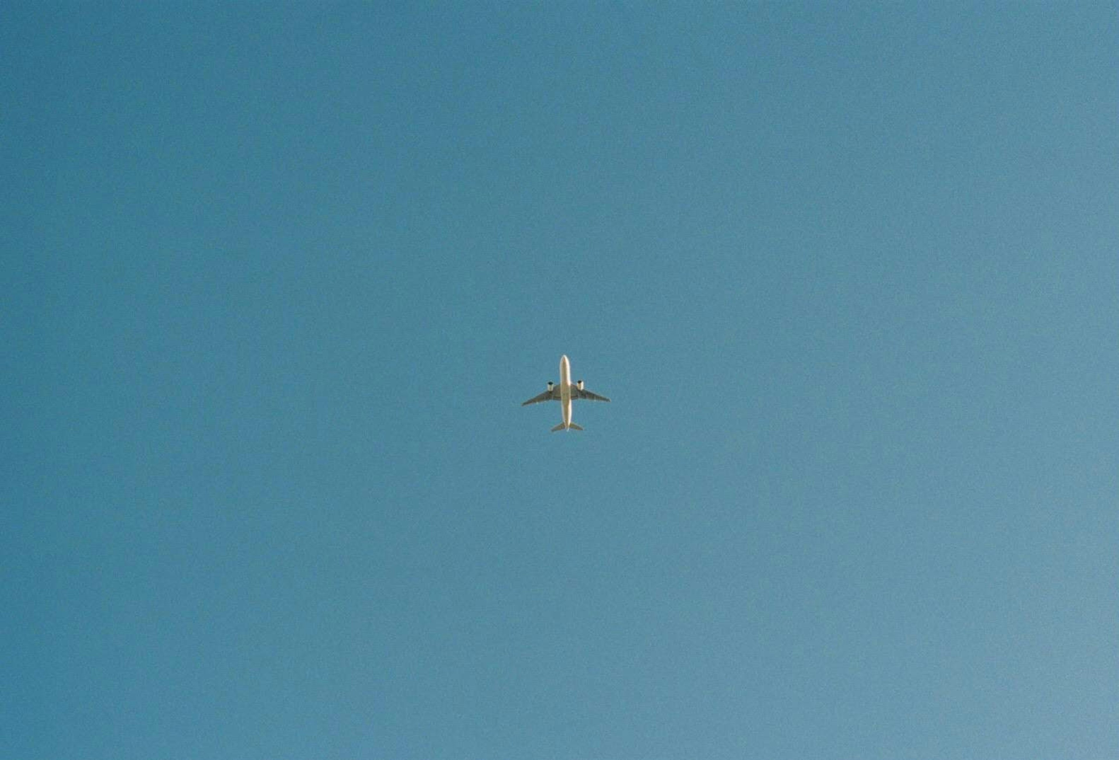 青空に浮かぶ飛行機の上面