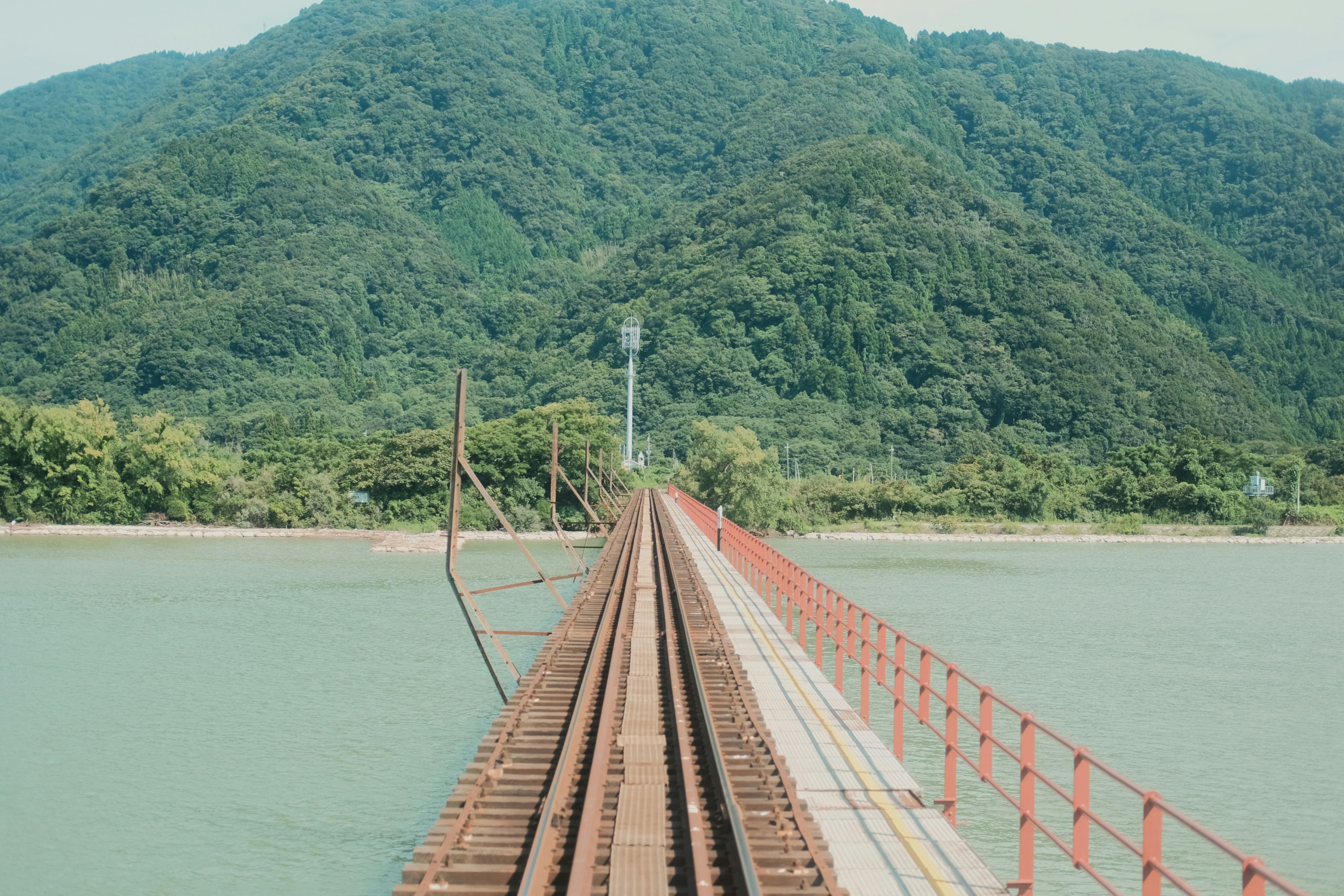 橋が水面を越えて山に向かう風景