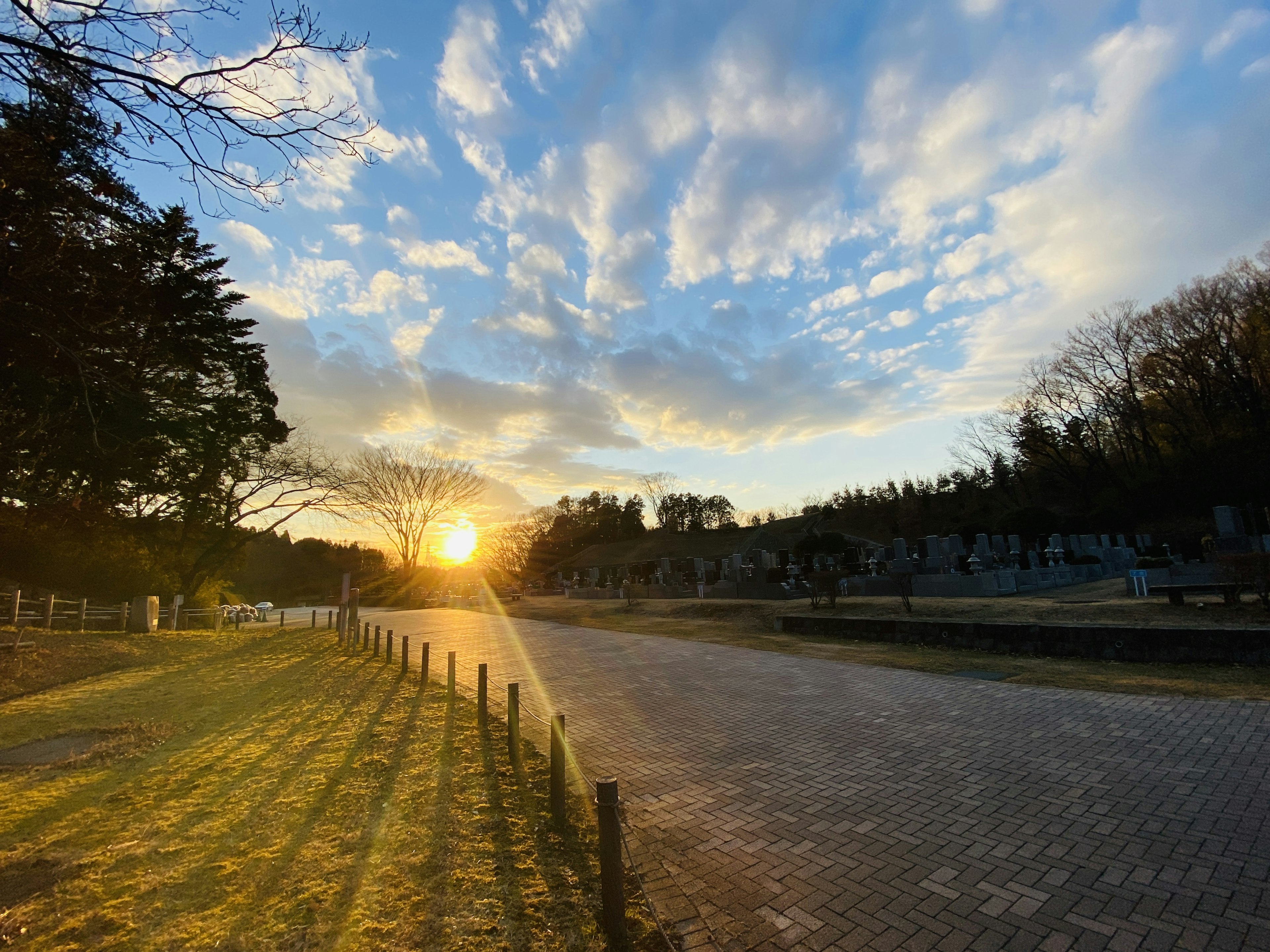 ทิวทัศน์สวนสาธารณะในยามพระอาทิตย์ตกดินพร้อมท้องฟ้าสีฟ้าและเมฆ