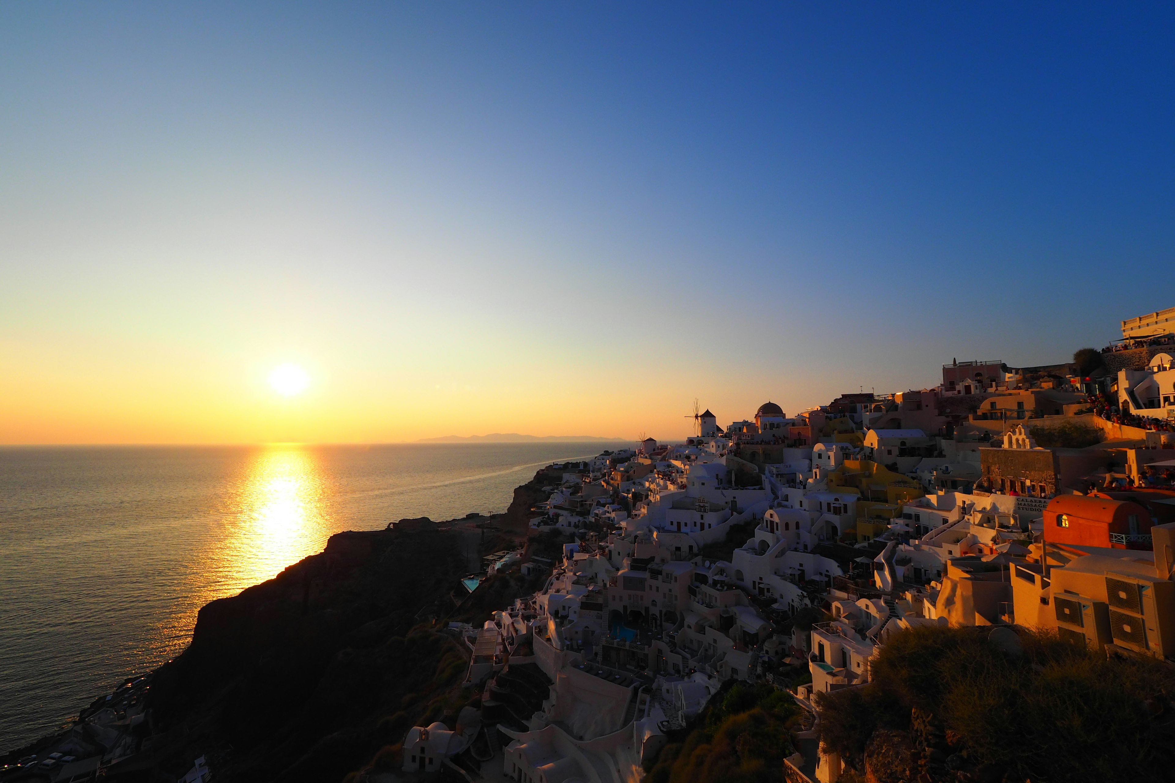 Hermoso atardecer sobre el mar en Santorini Casas blancas a lo largo del acantilado