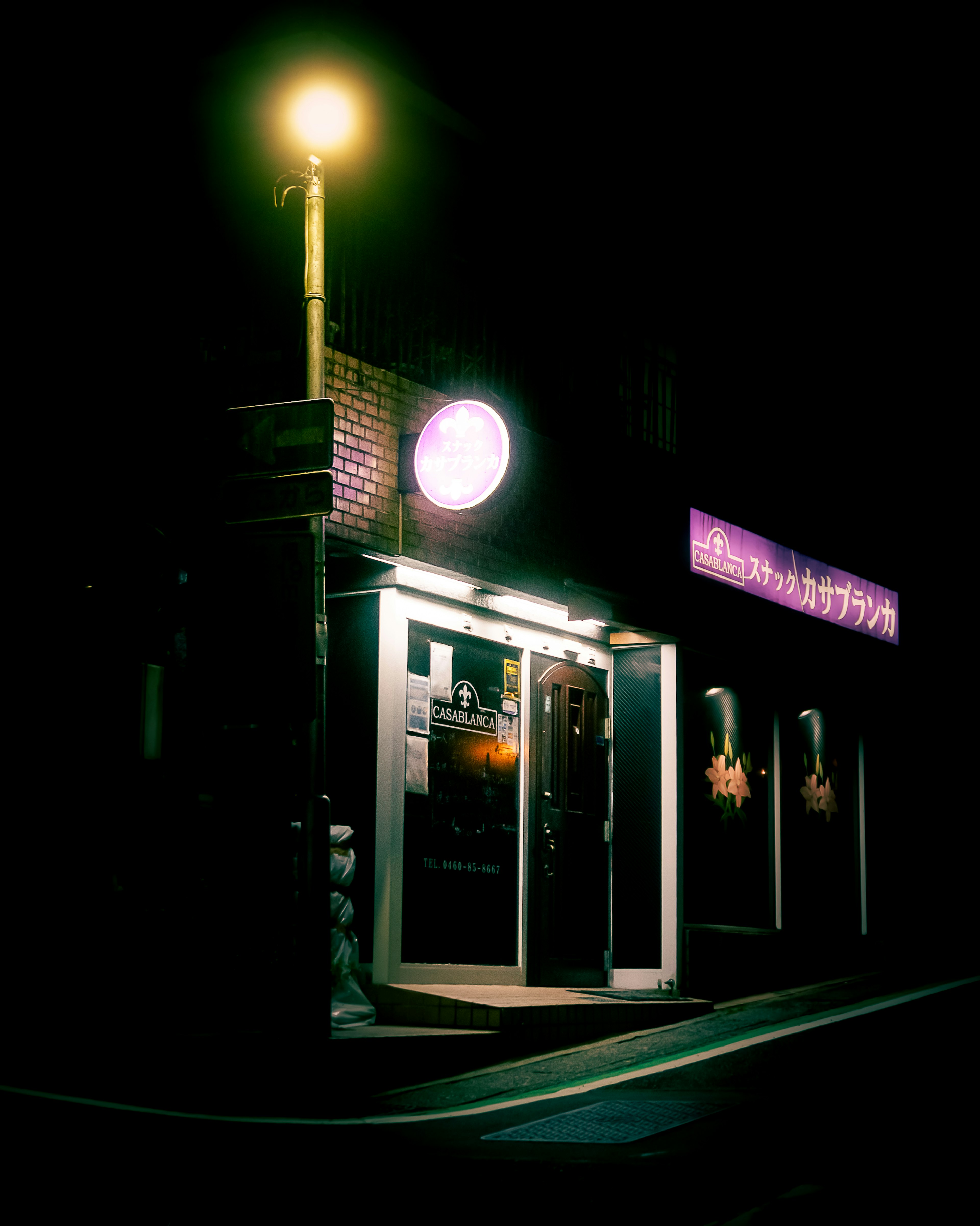 Brightly lit storefront at night on a street corner