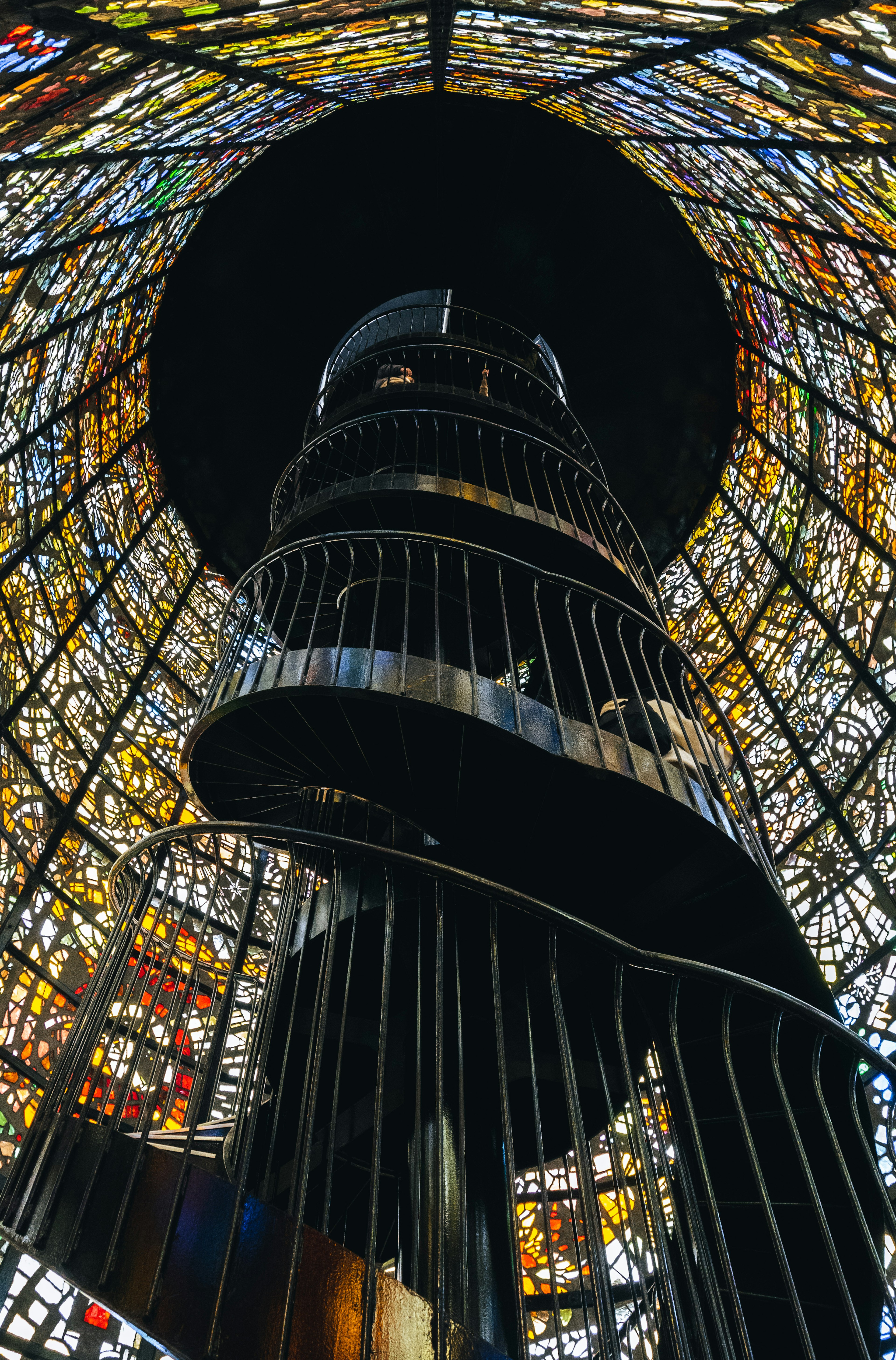 Interior of a spiral staircase surrounded by beautiful stained glass