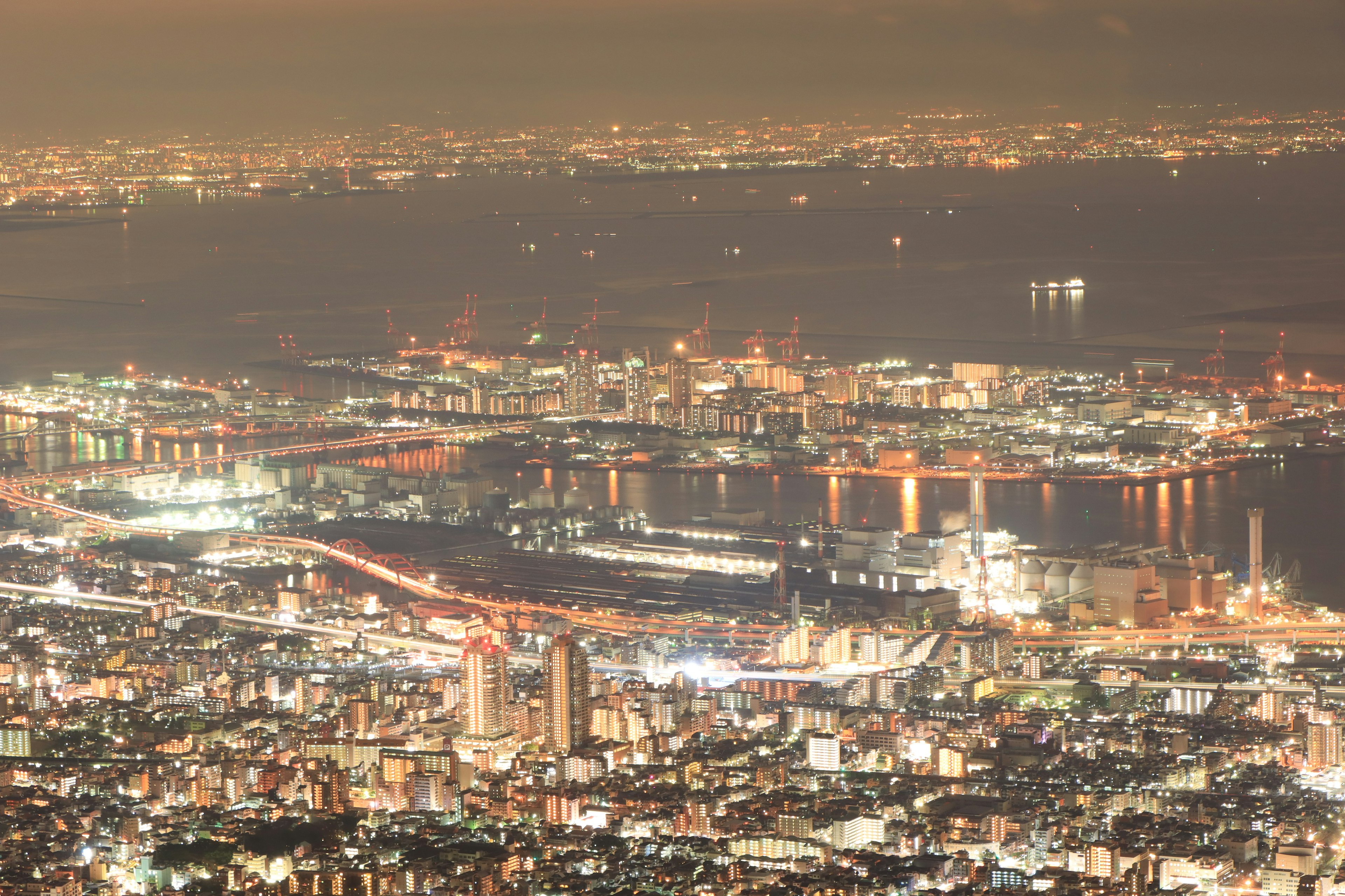 夜景の都市のパノラマビュー明るい光が輝くビルと港