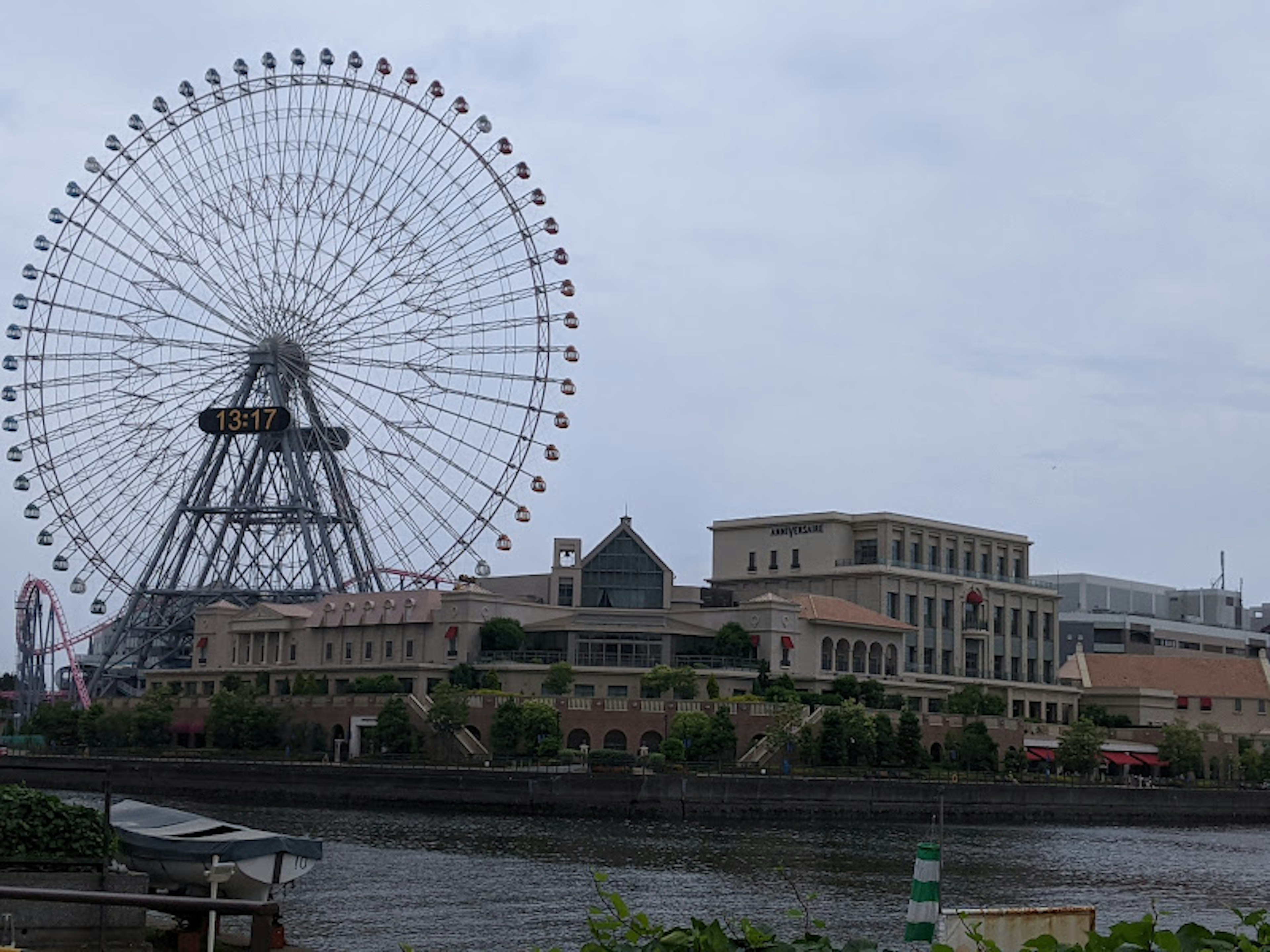 Large Ferris wheel beside a riverside building