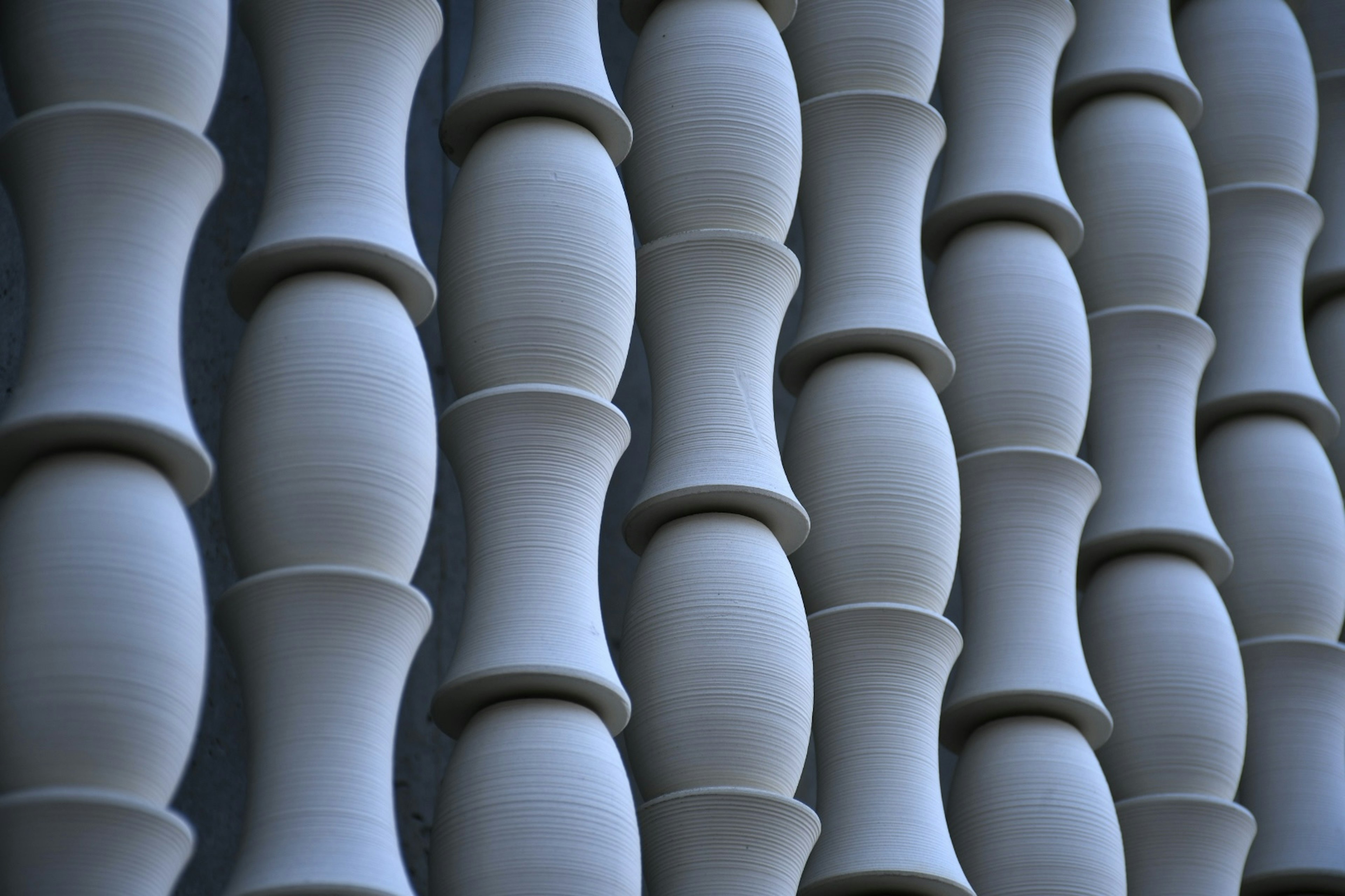 Unique shaped objects arranged on a blue ceramic wall