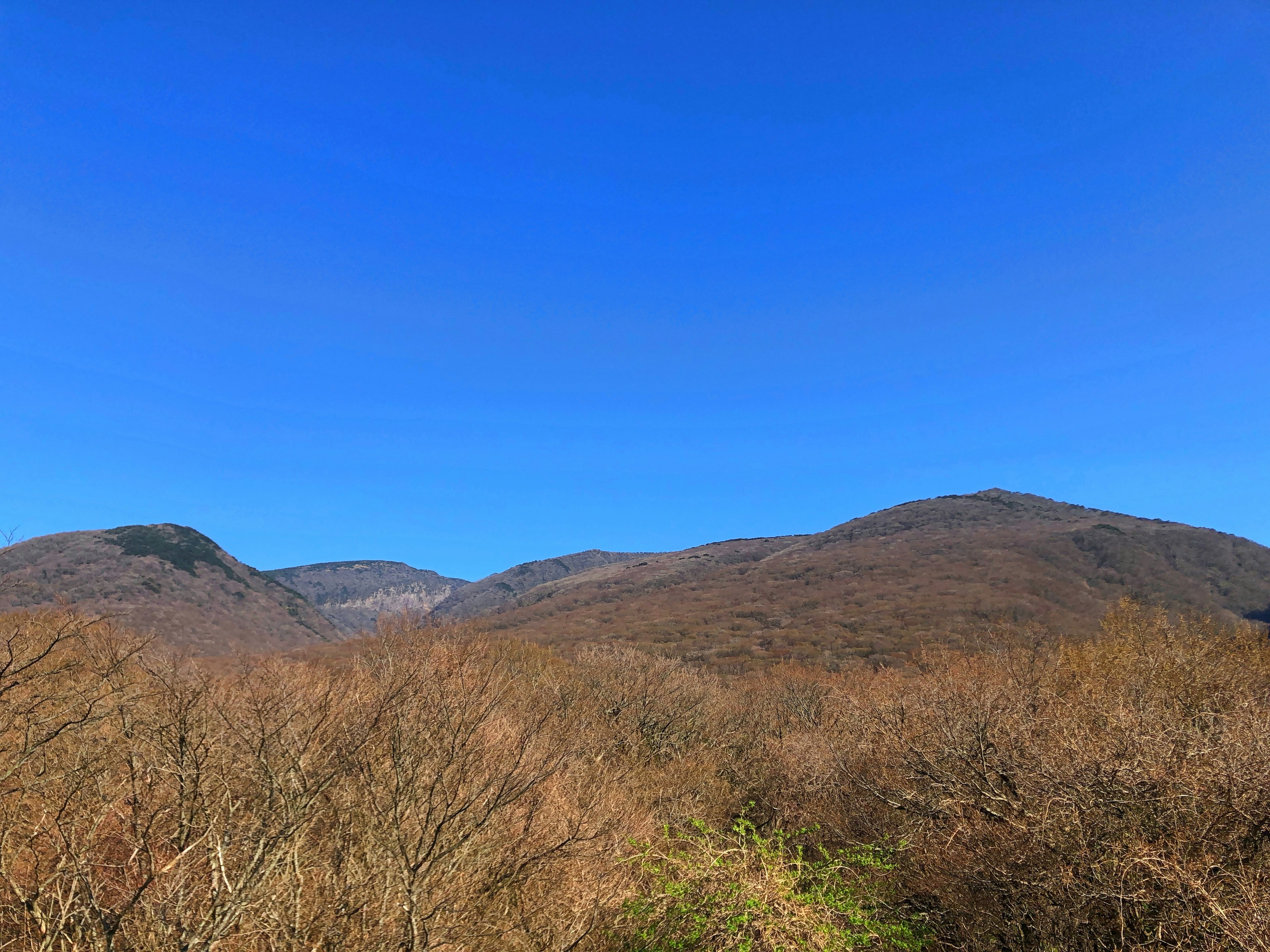 Landscape featuring brown mountains under a clear blue sky