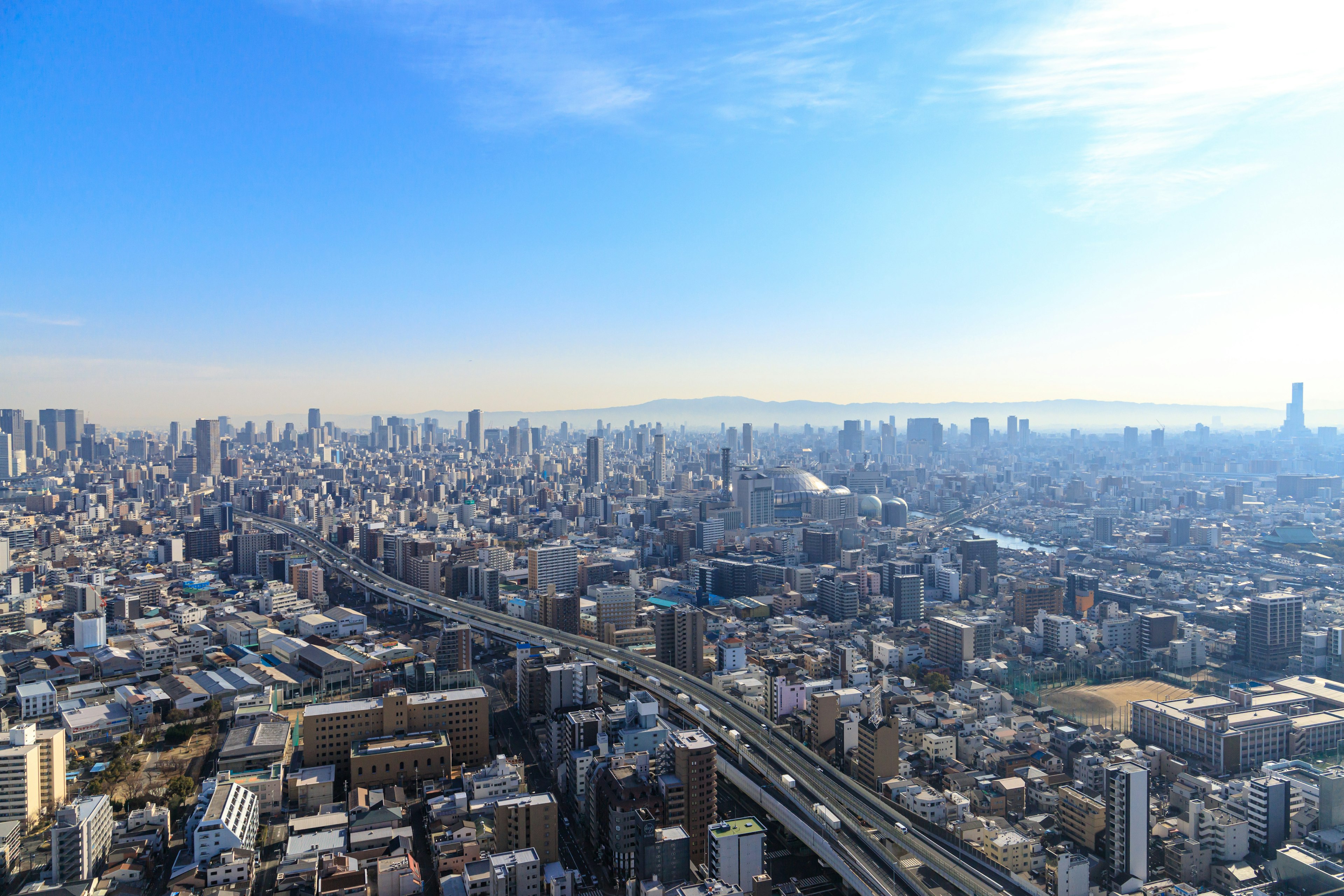 Pemandangan kota Tokyo dengan gedung dan jalan di bawah langit biru cerah