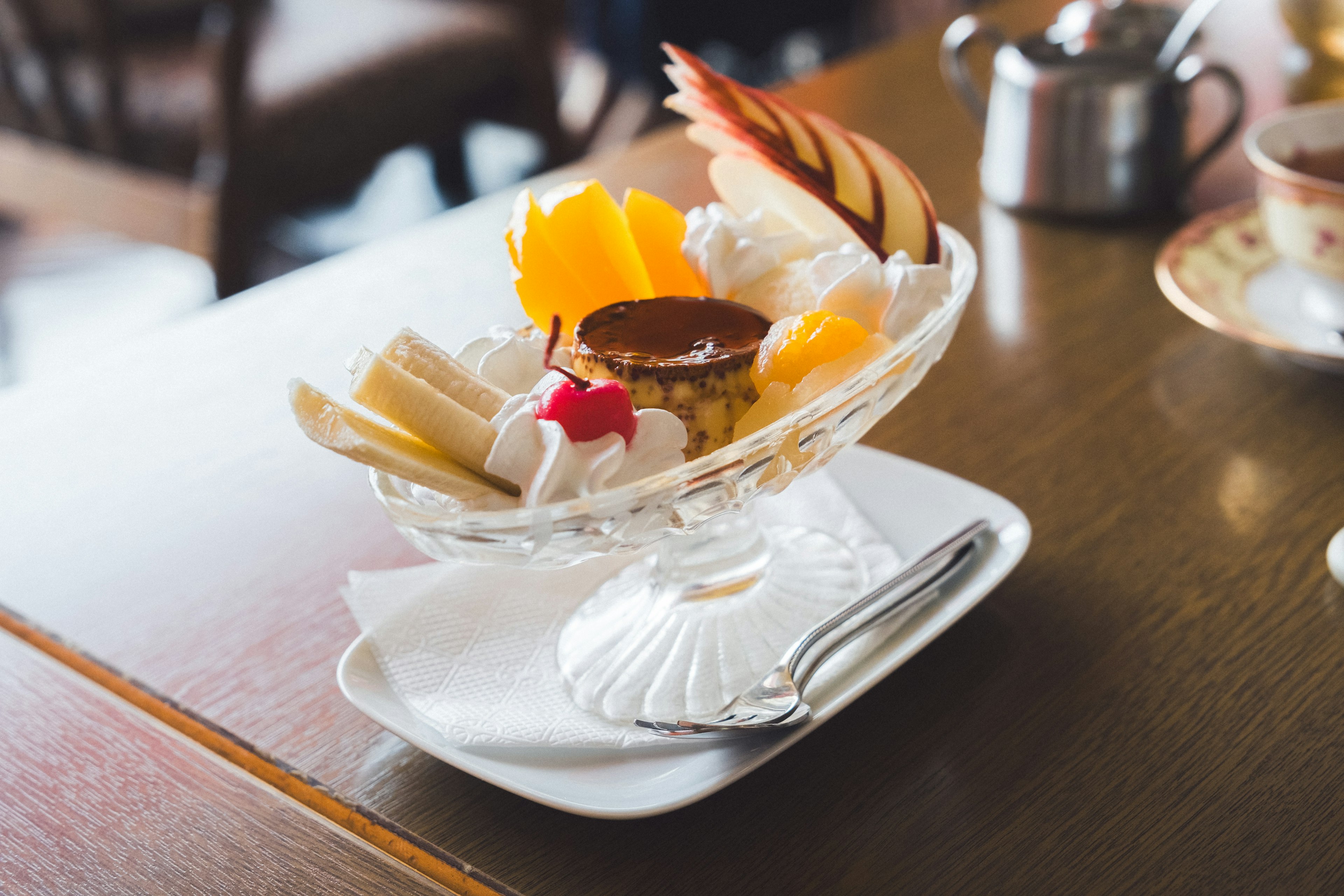 Bunter Obst-Sundae in einer Glasschüssel mit einem Löffel