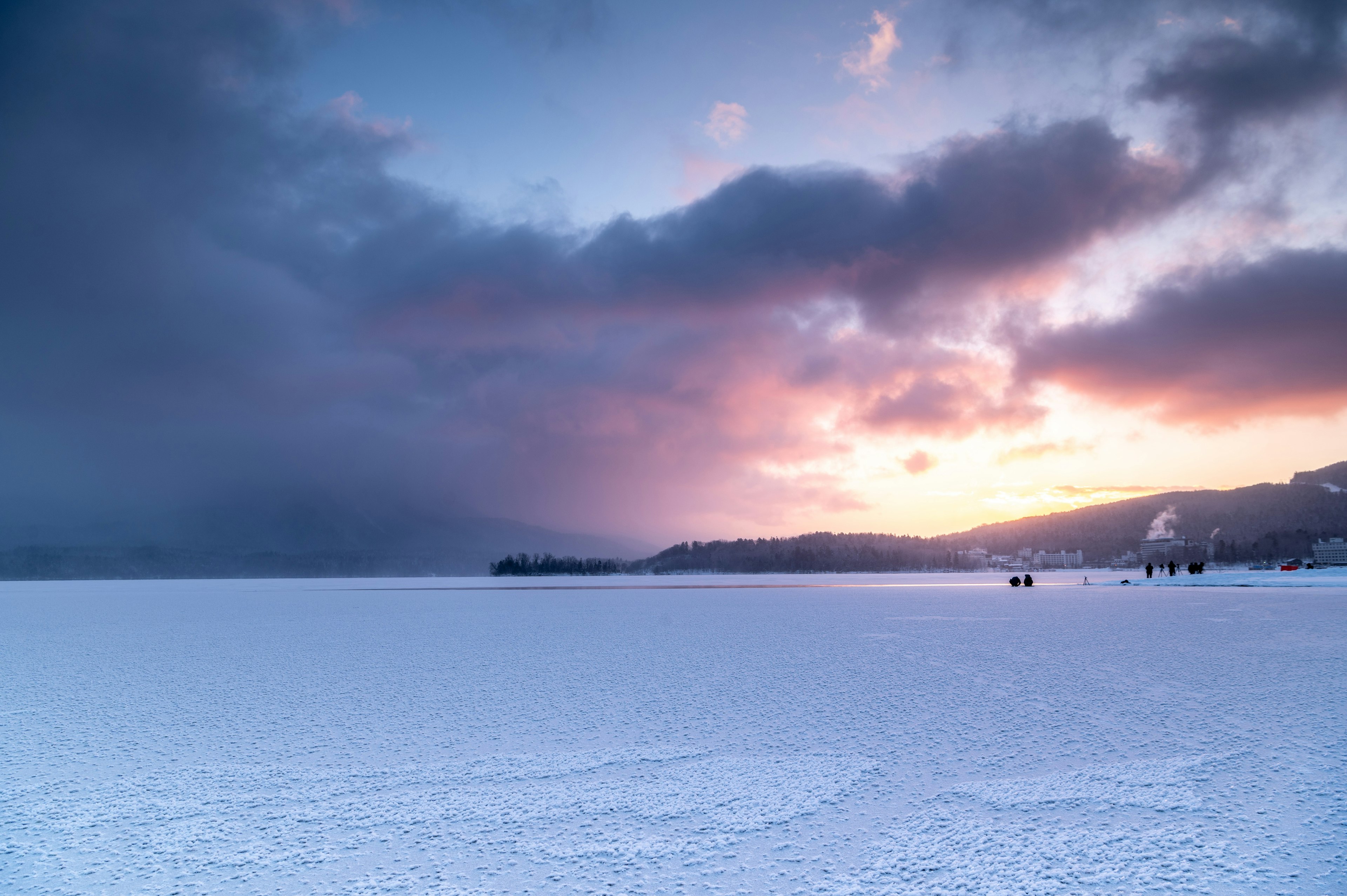 雪に覆われた湖の広大な風景と美しい夕焼け