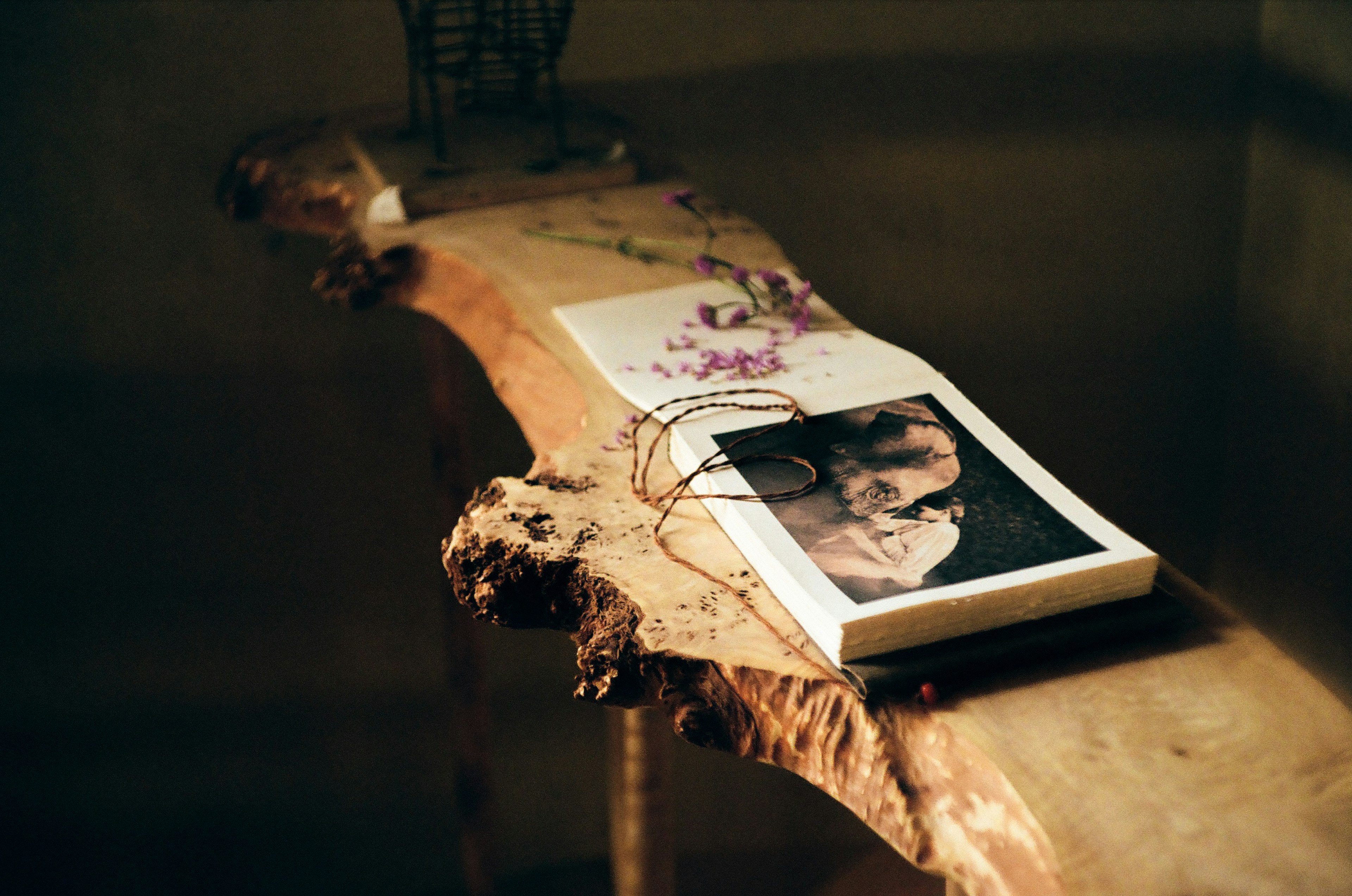 A book and a floral photo placed on a wooden table