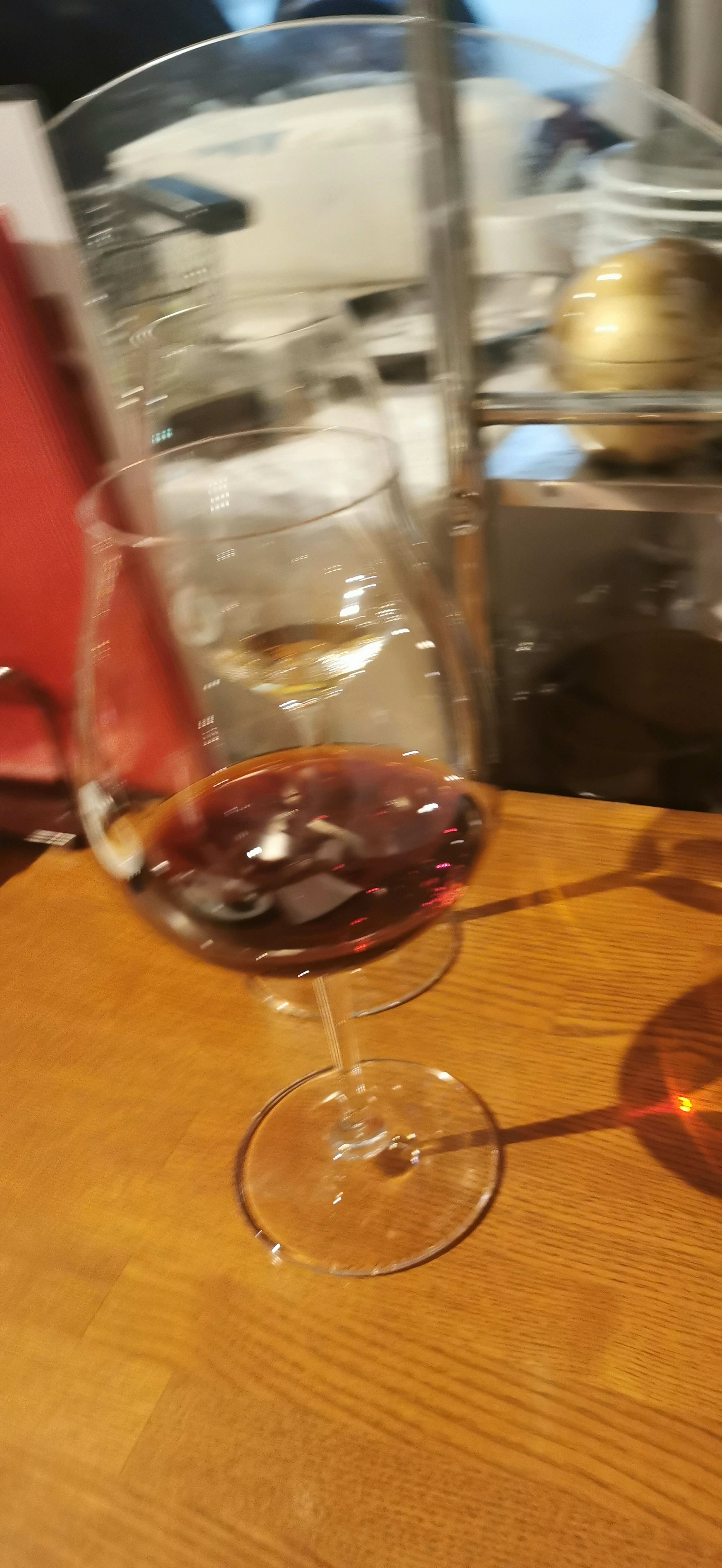 A glass of red wine on a wooden table with blurred background