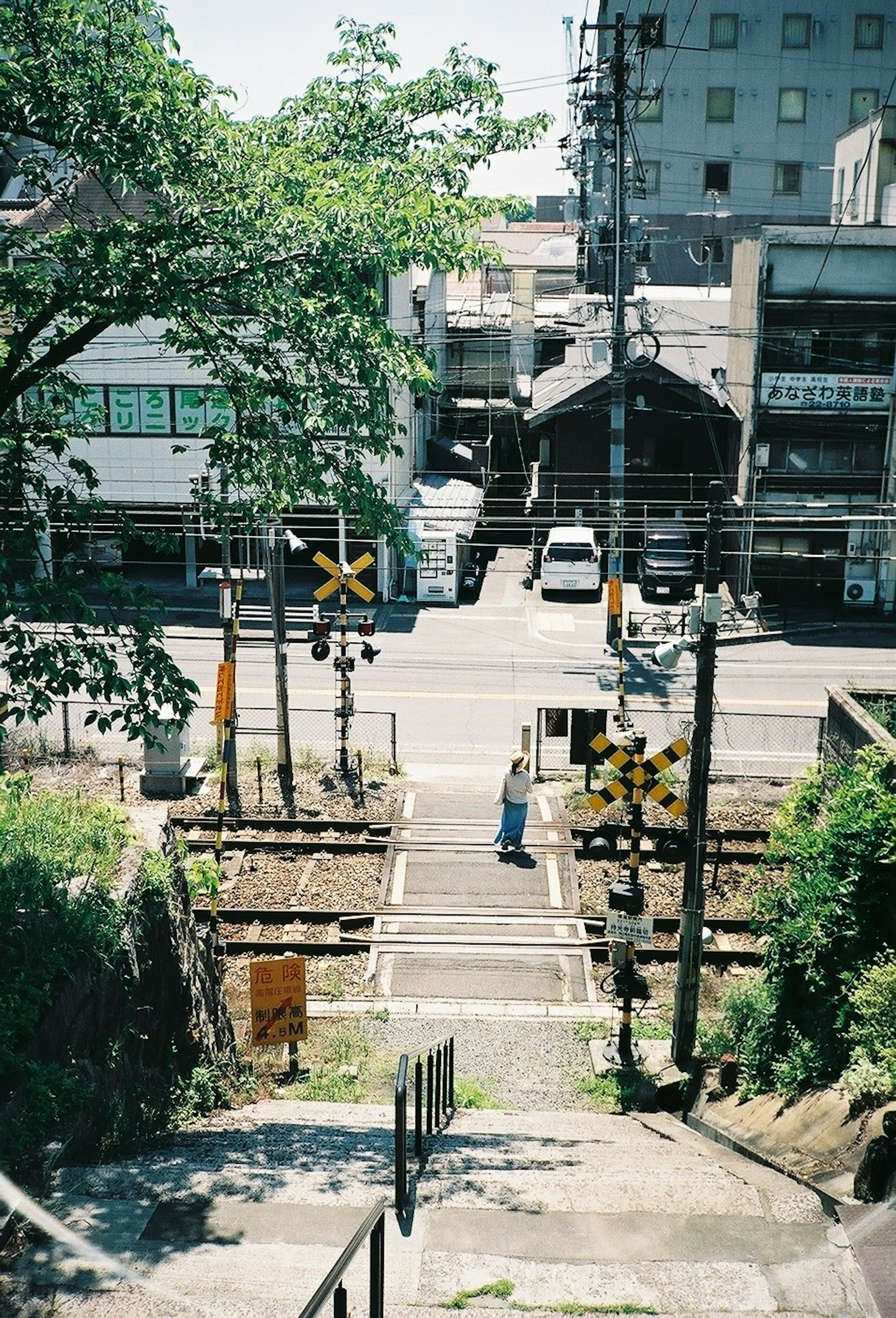 線路のある街の風景と階段を下りる人物