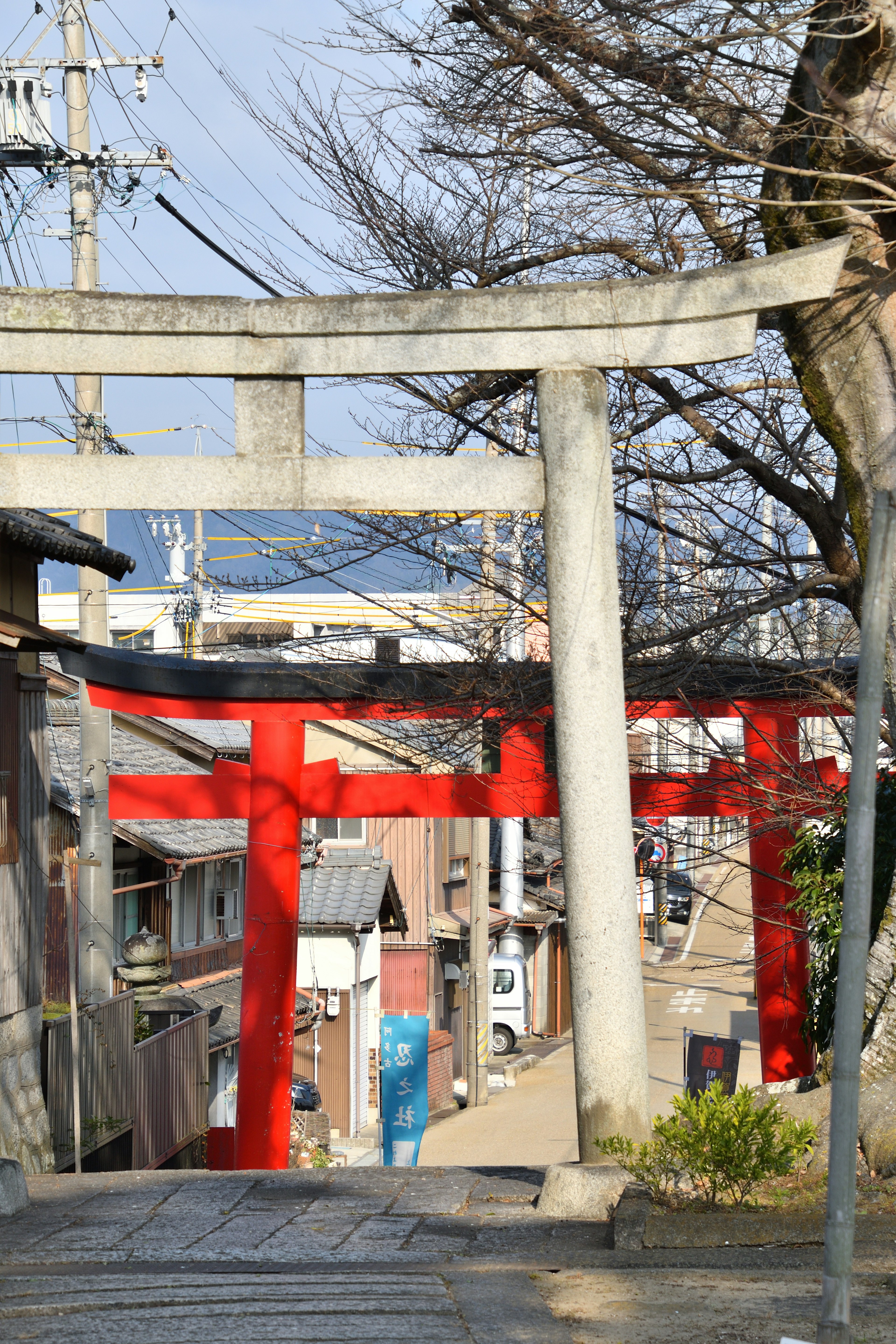 Vista de un torii rojo y un torii de piedra