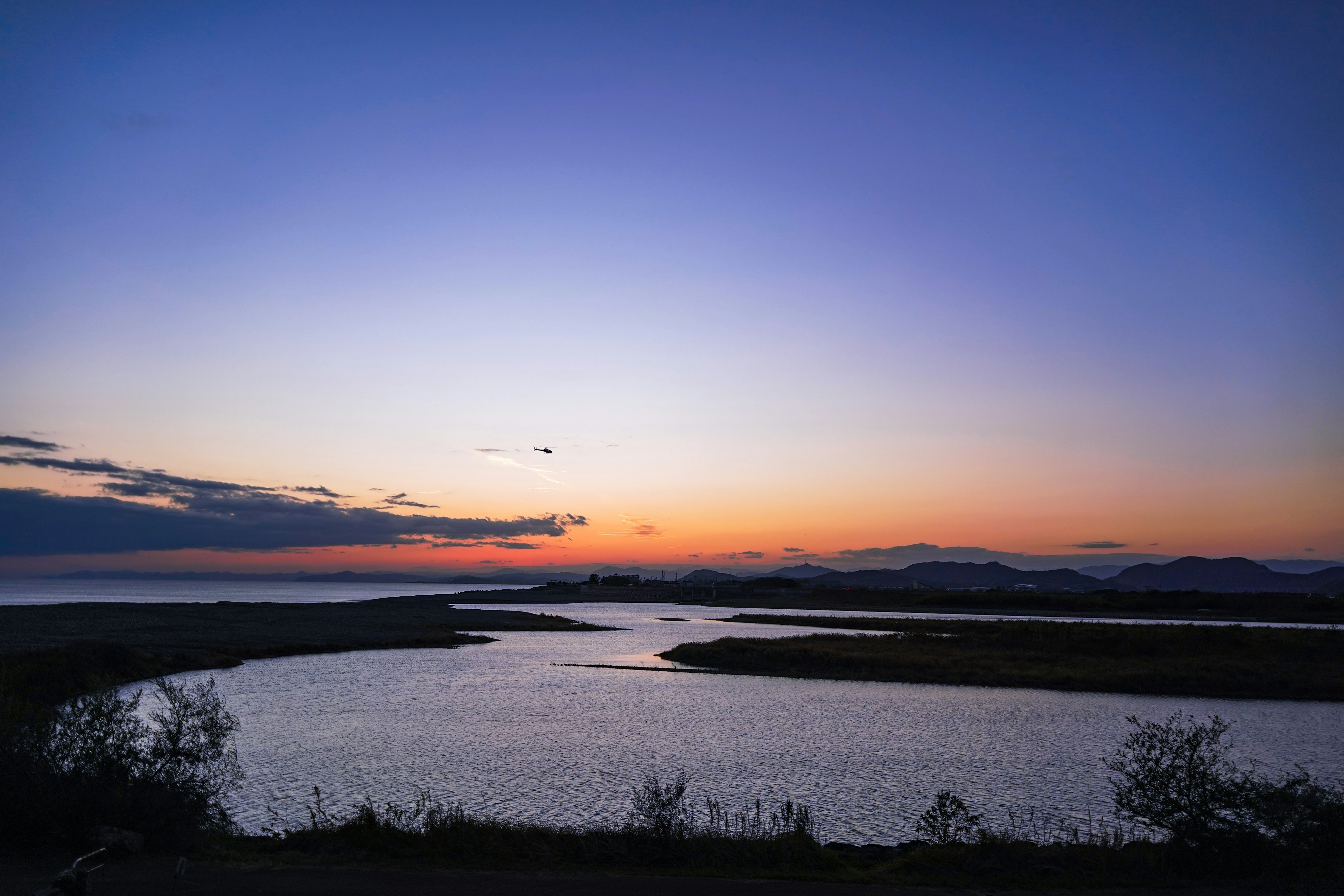 静かな川が流れる美しい夕焼けの風景