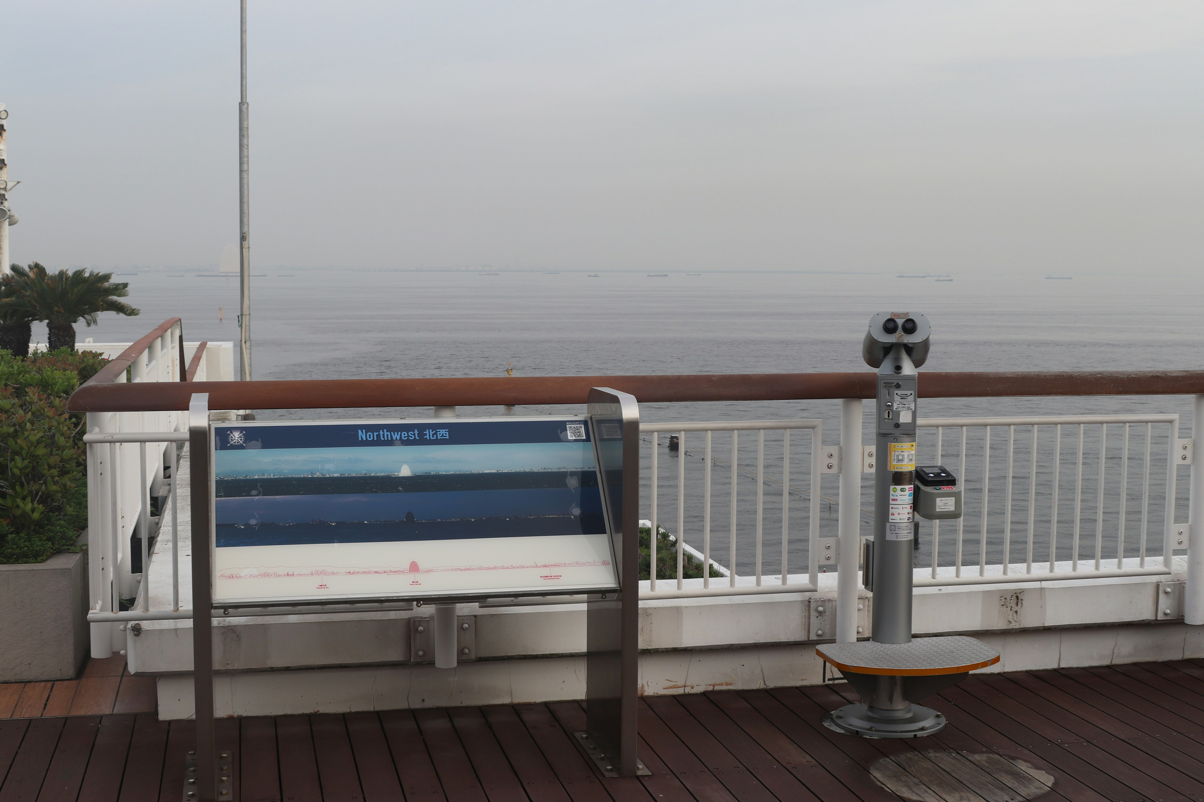 Point de vue avec jumelles surplombant la mer et une terrasse en bois