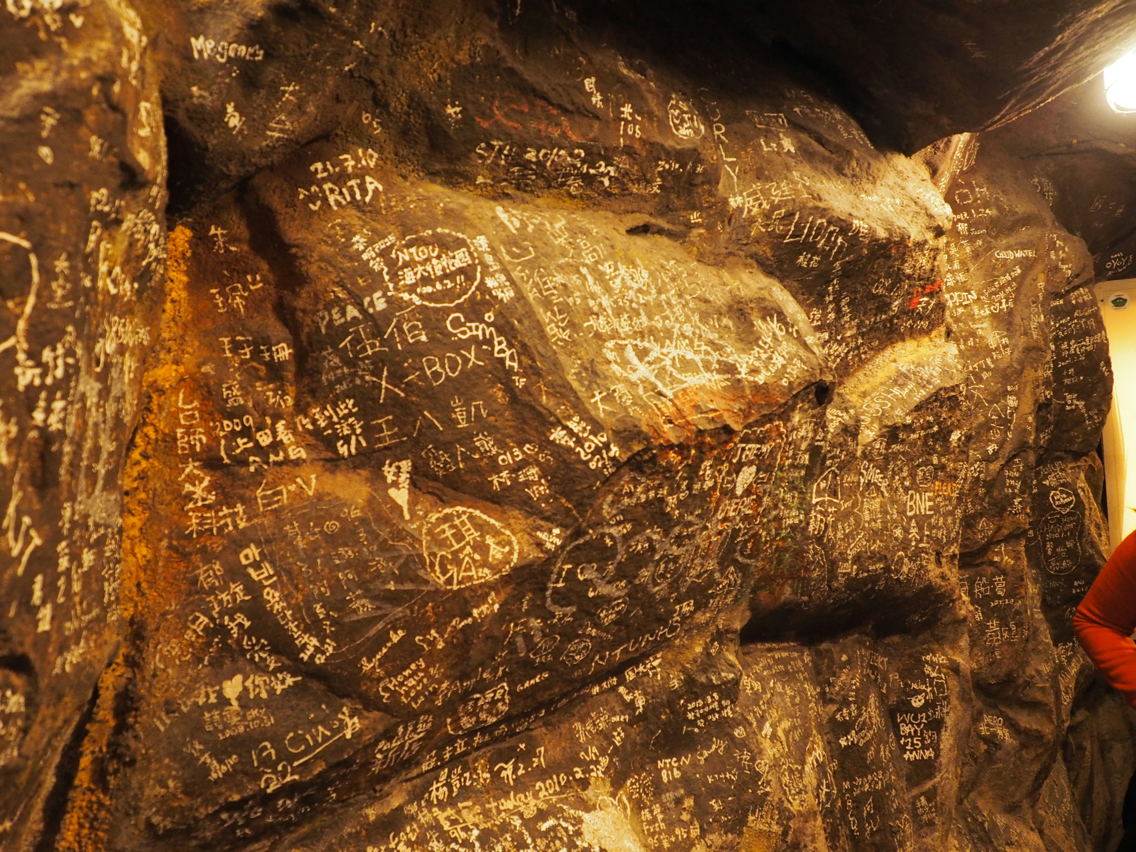 Mur de roche couvert de nombreuses gravures et messages