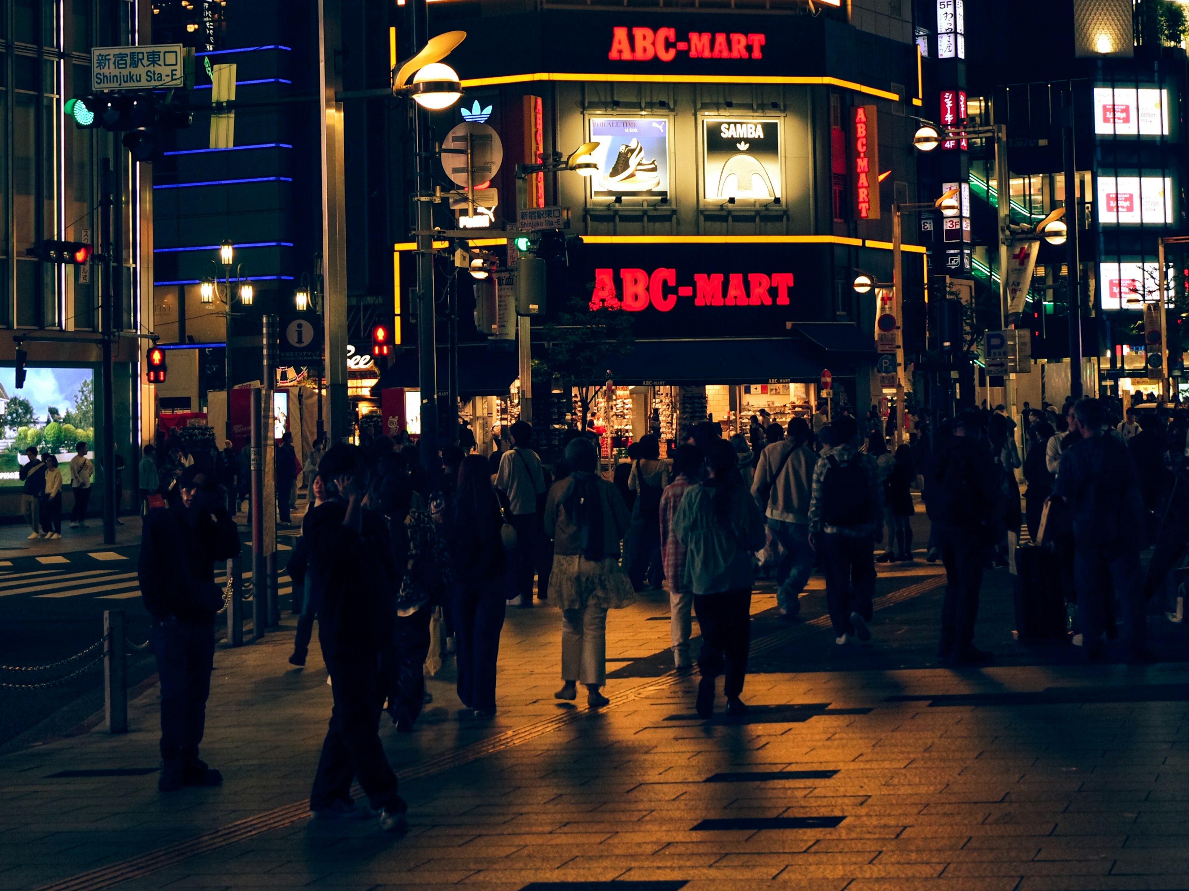Crowd of people walking in front of ABC-MART in a vibrant nightlife setting