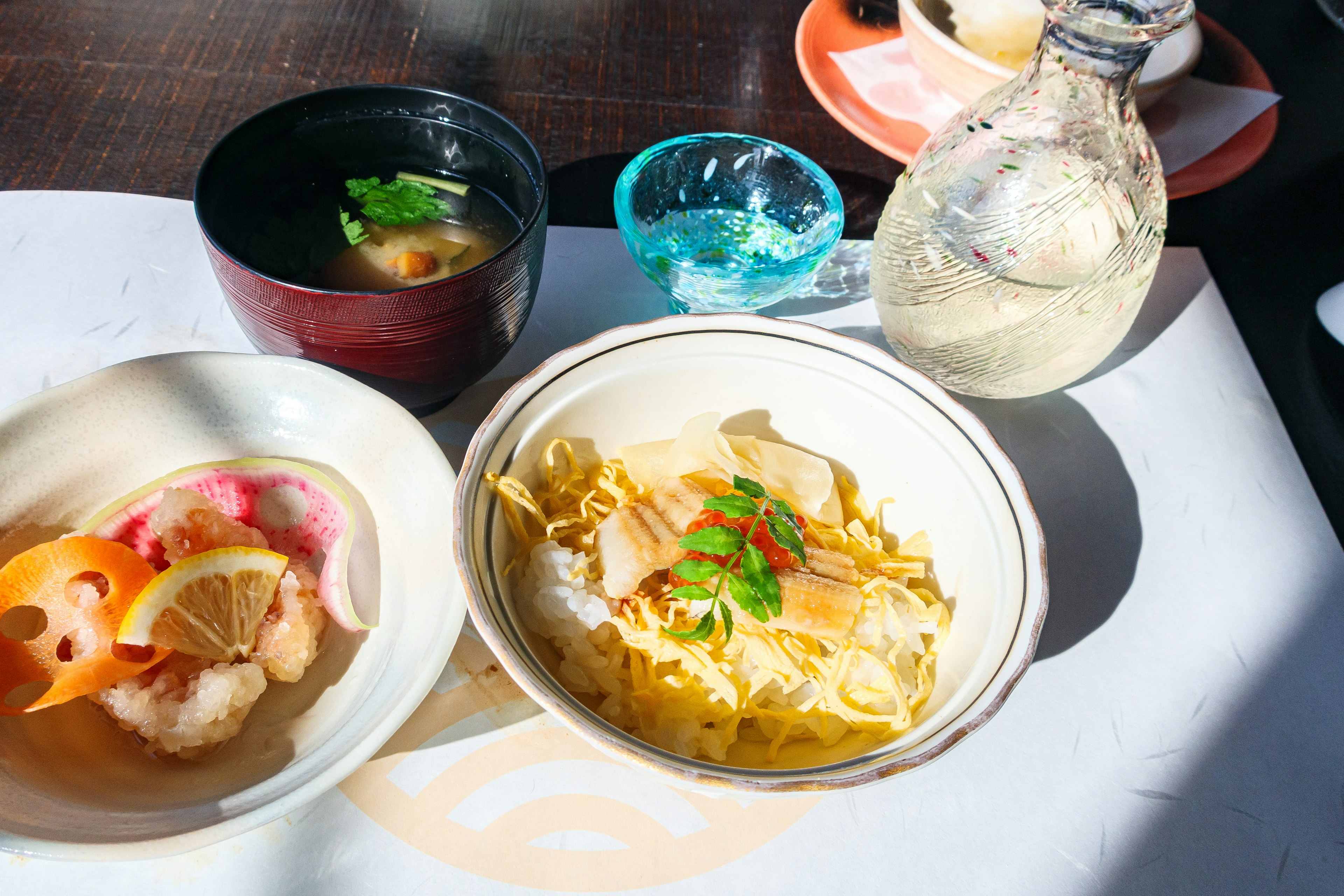 Presentación de la cocina japonesa con fideos cubiertos de pollo y aperitivos coloridos