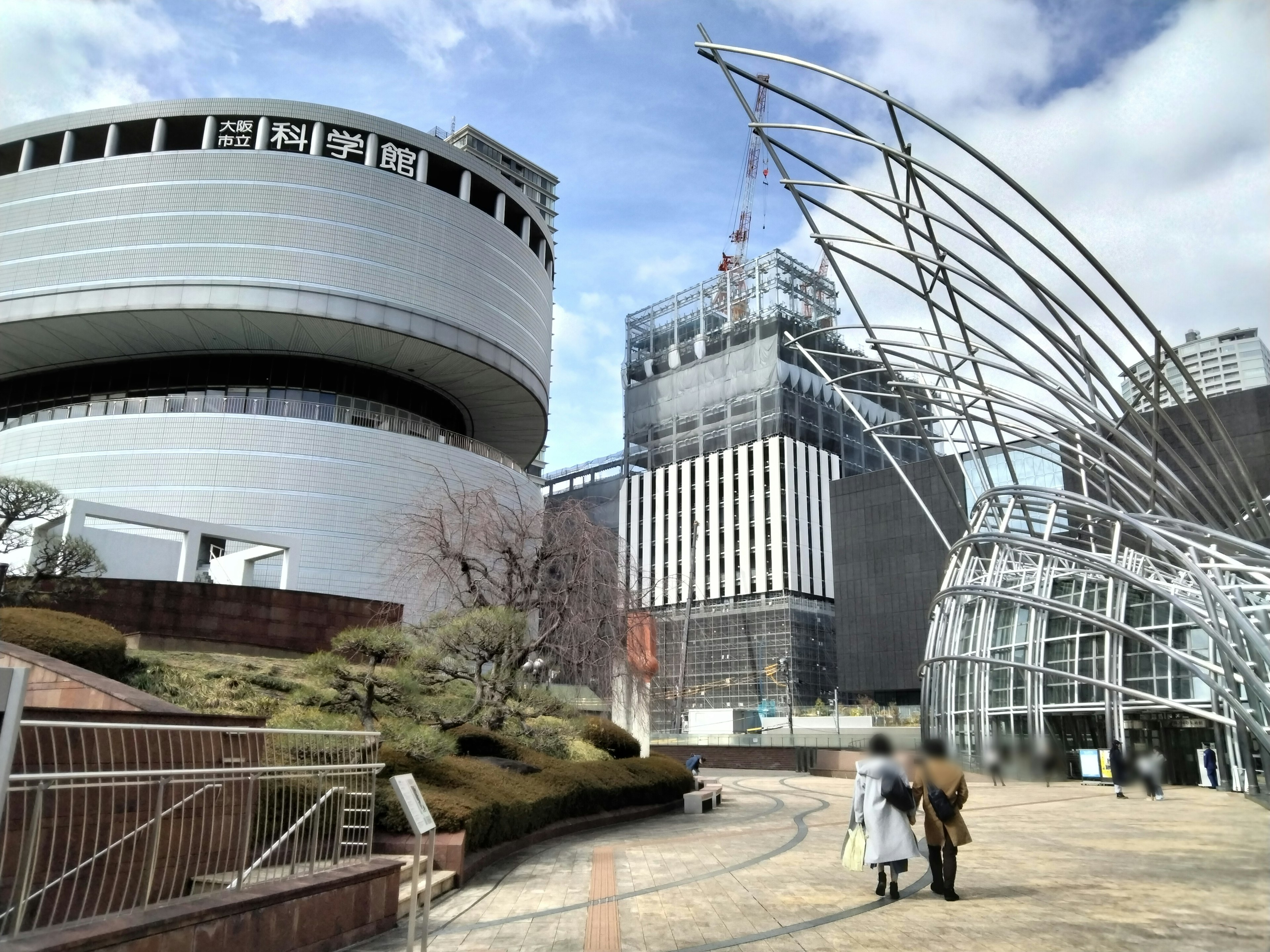 Paisaje urbano con arquitectura moderna que presenta estructuras curvas y un edificio circular