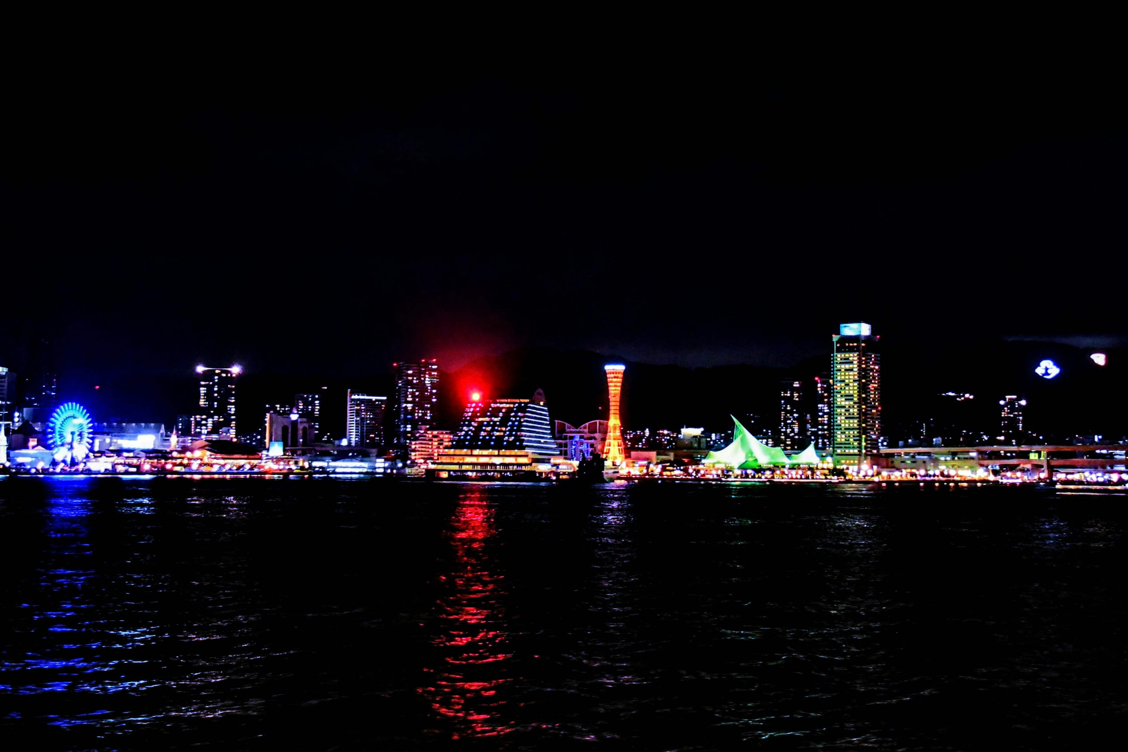 Skyline notturno della città con luci colorate che si riflettono sull'acqua