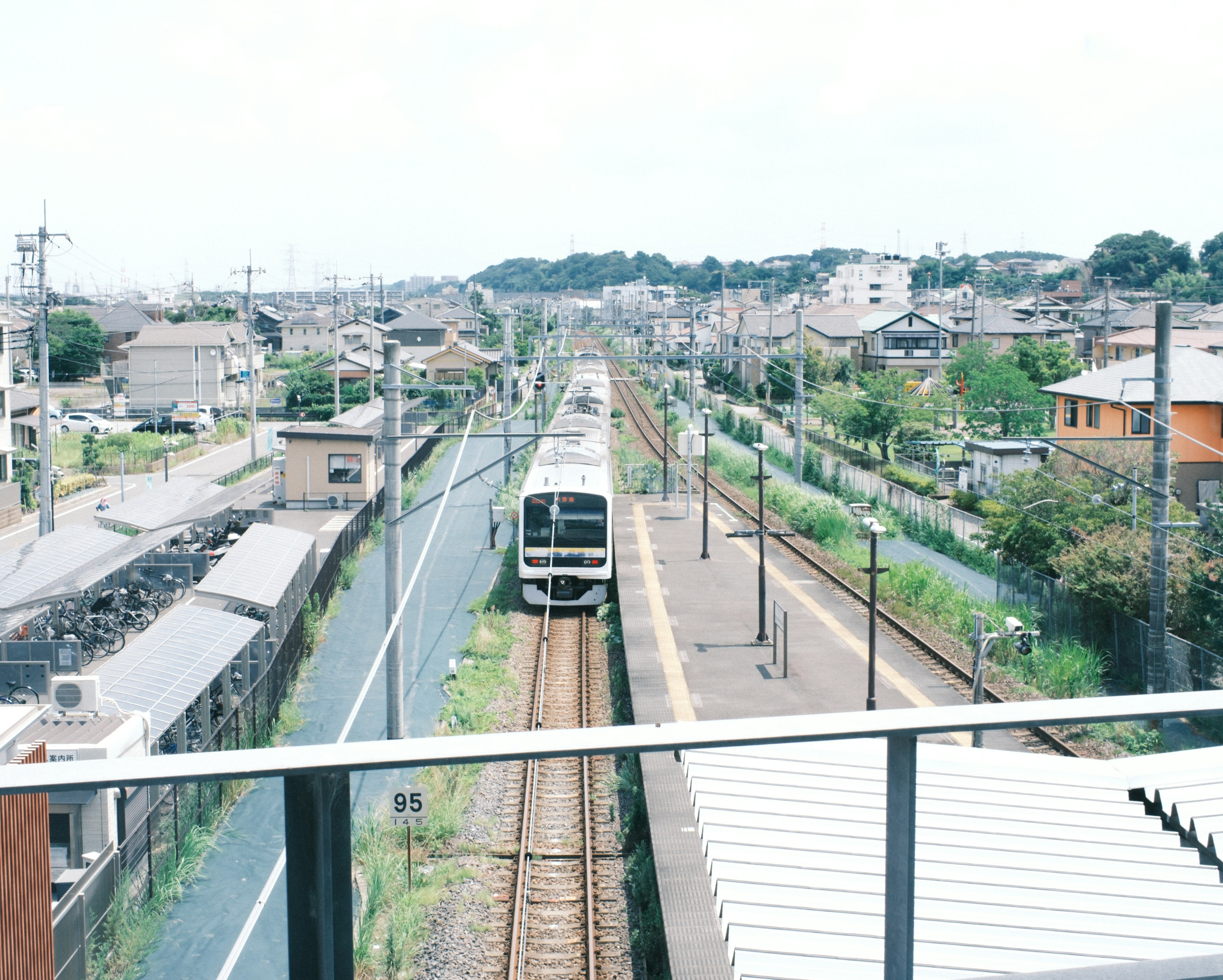 Estación de tren con un tren en las vías en un entorno rural