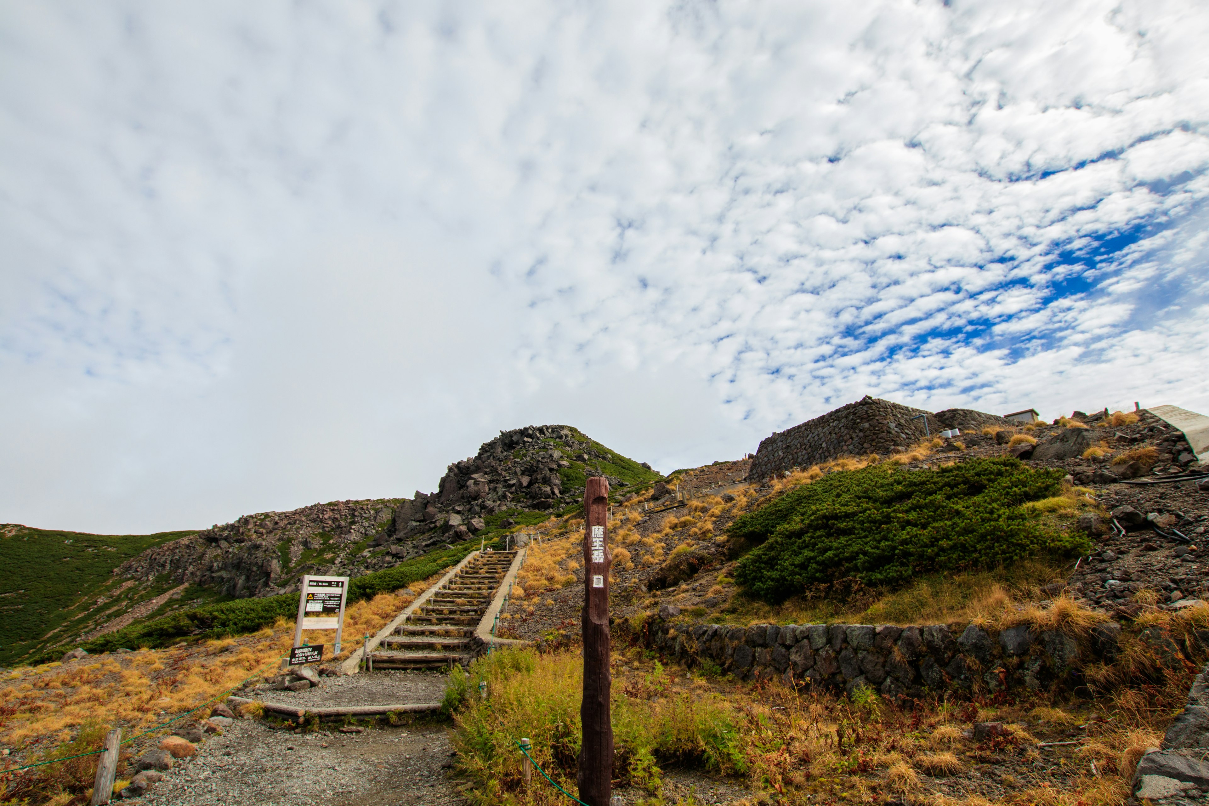 Path leading to rocky hills under a cloudy sky