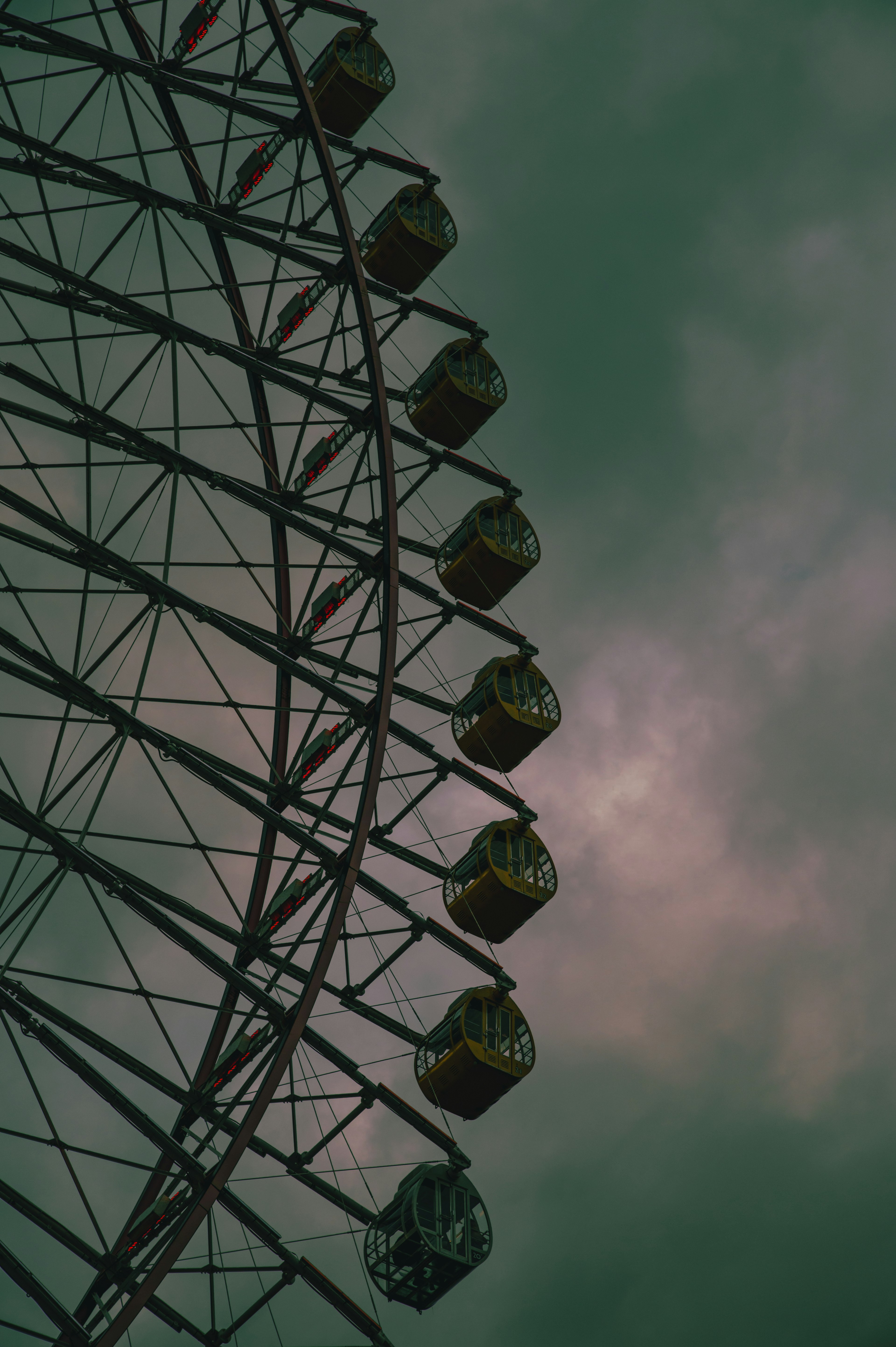 Side view of a Ferris wheel under a dark sky