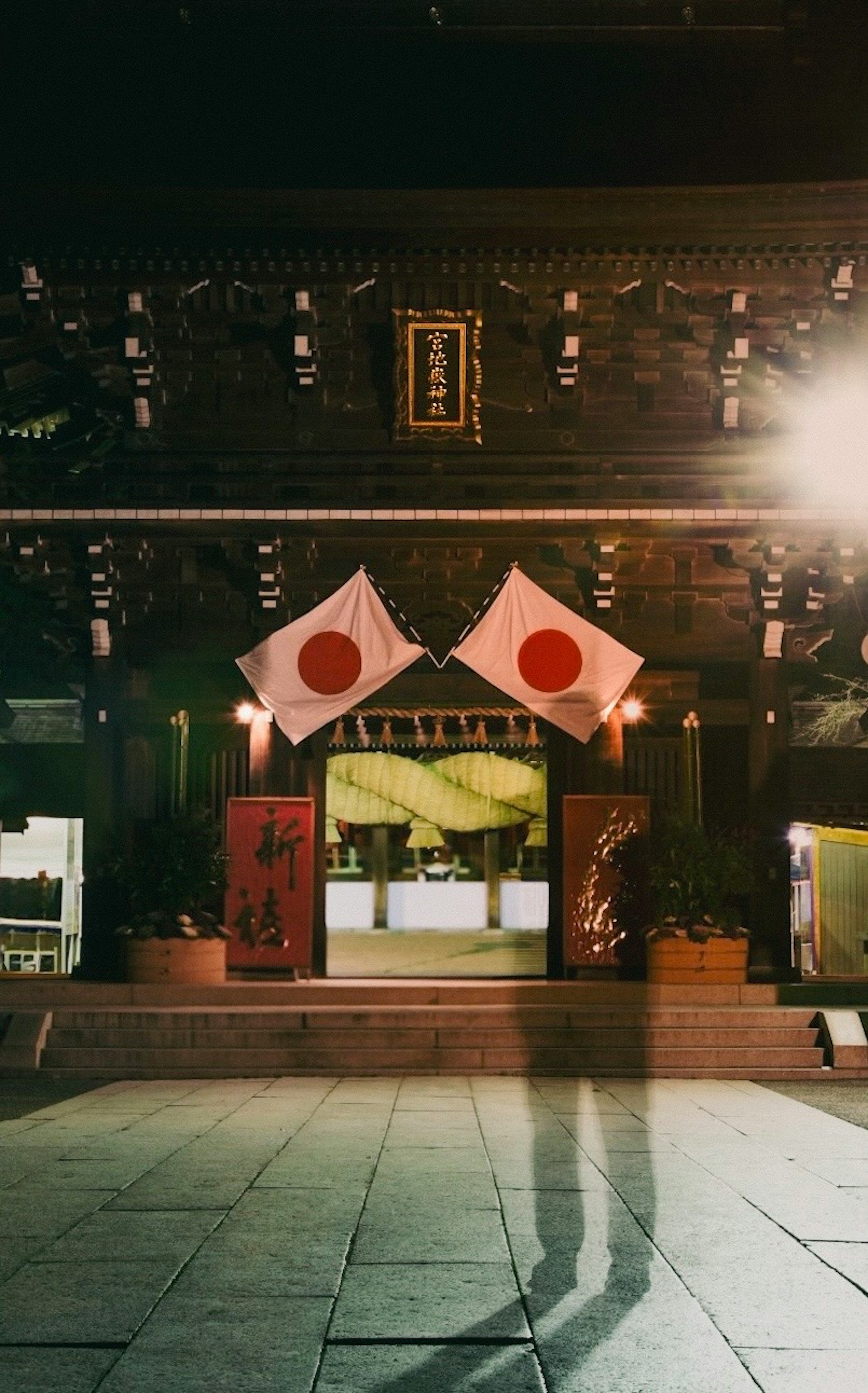 Vista nocturna de un edificio tradicional con banderas japonesas exhibidas