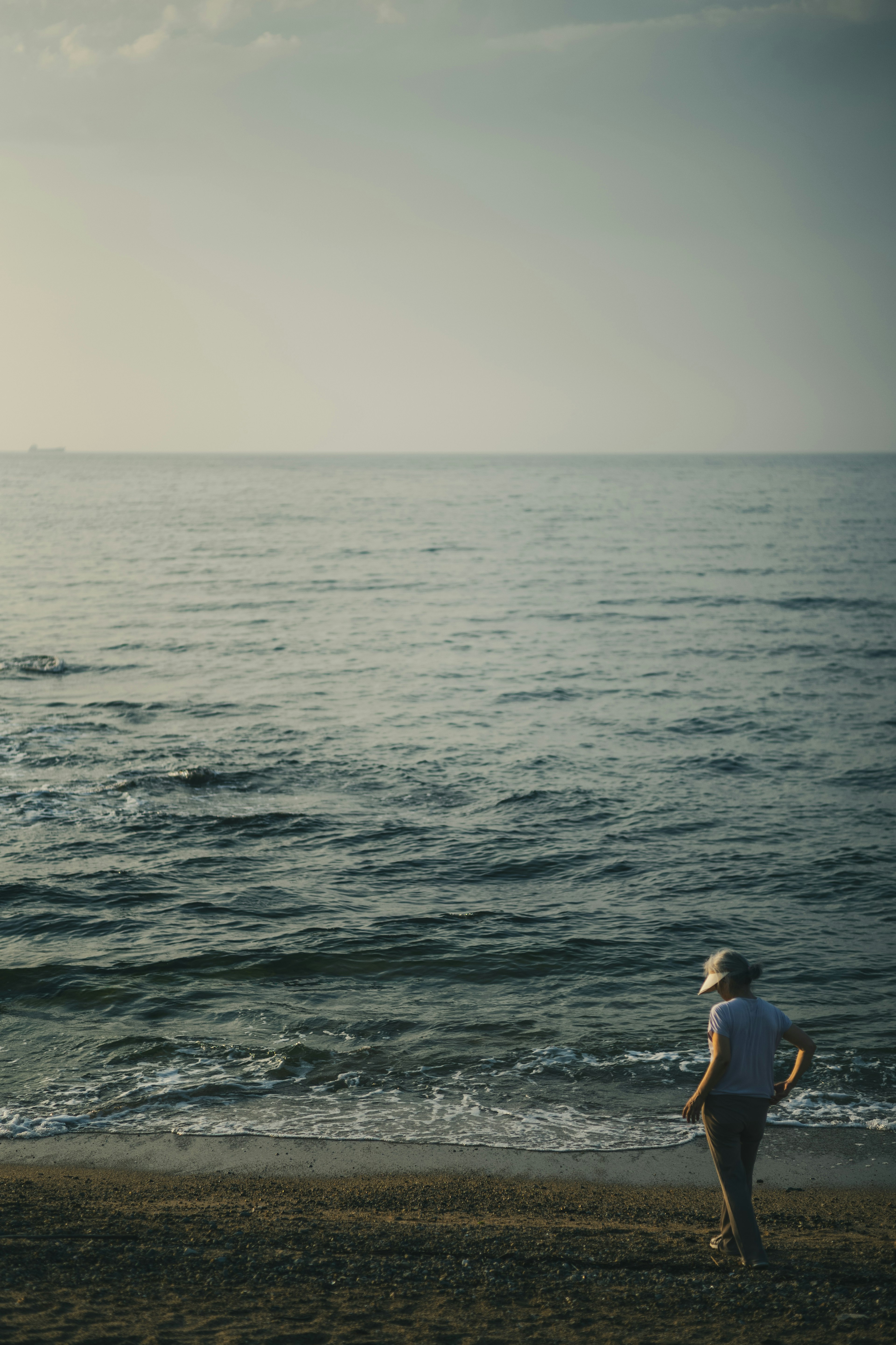 Une personne regardant la mer calme sur une plage