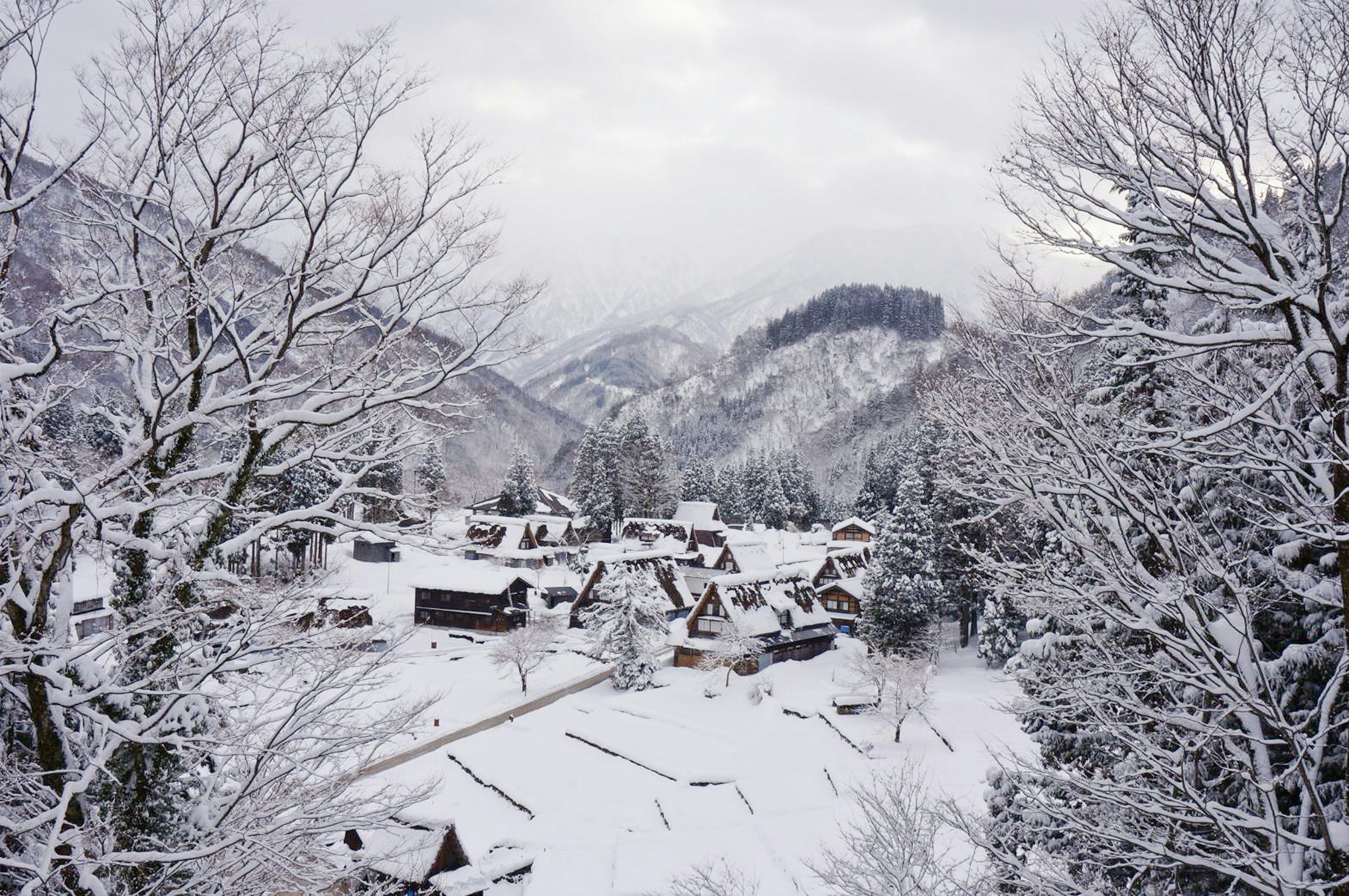 Verschneites Dorf mit Bergen im Hintergrund