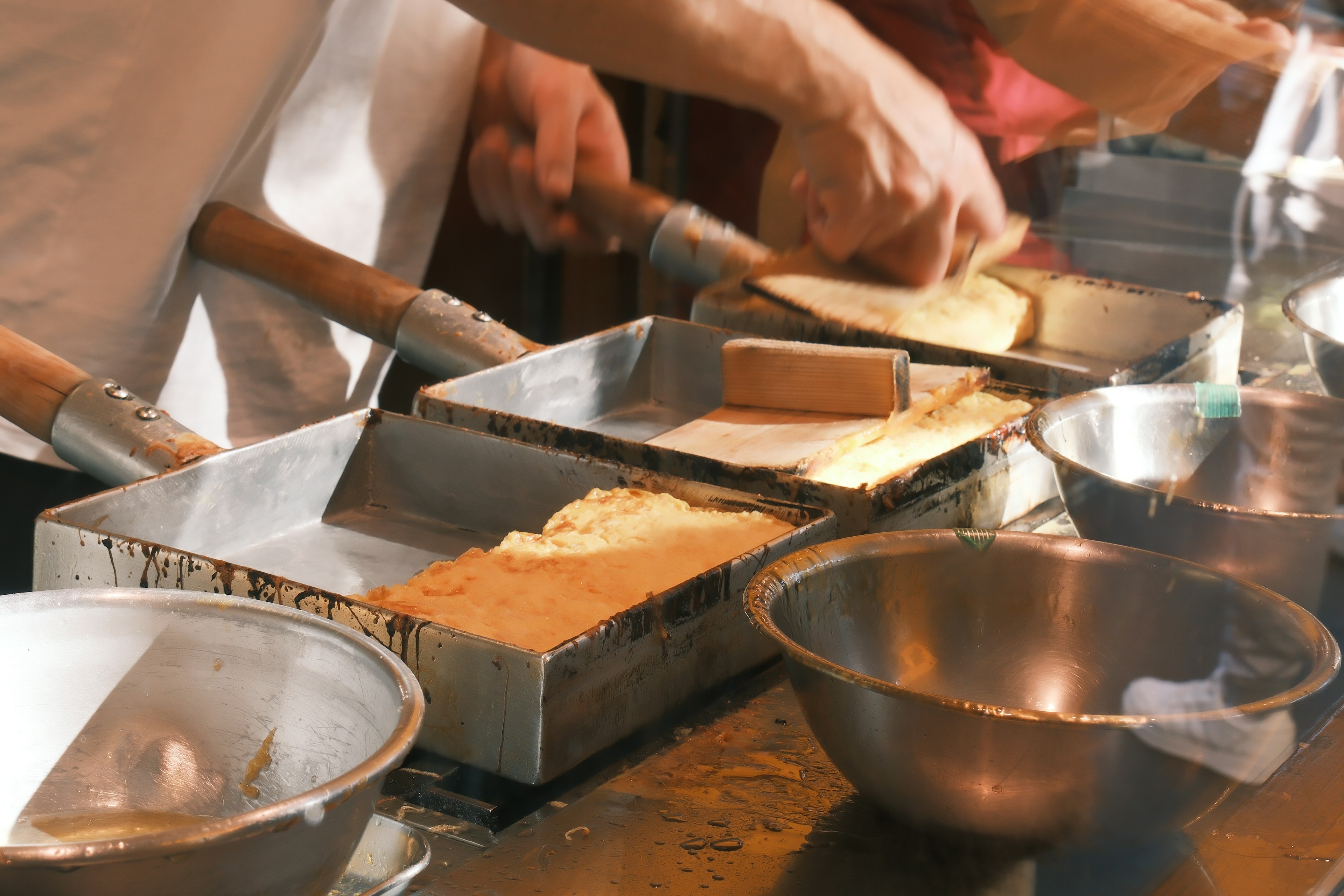 Des cuisiniers préparant de la pâte dans une cuisine