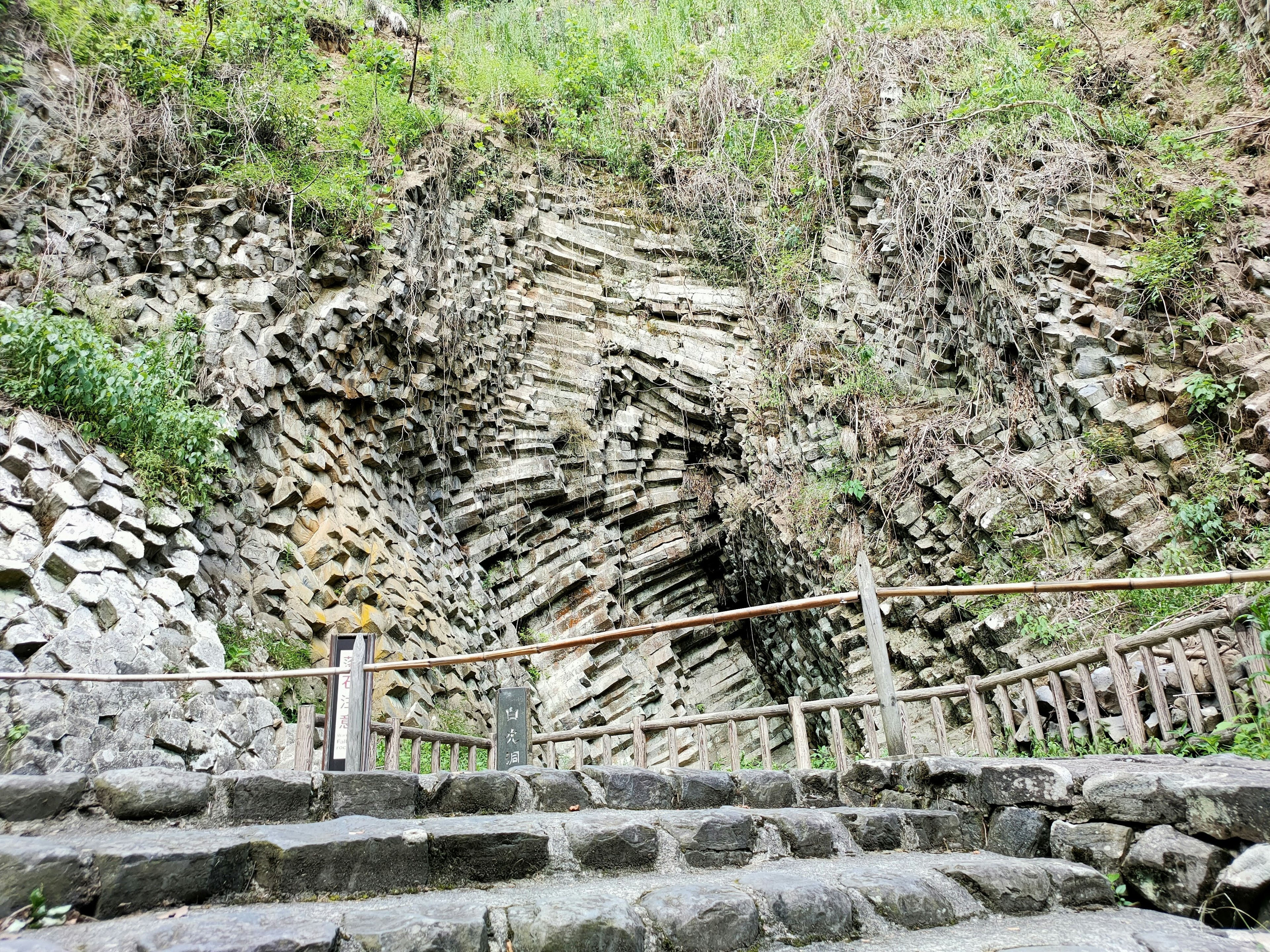 Staircase leading to a rocky cliff with layered stone formations