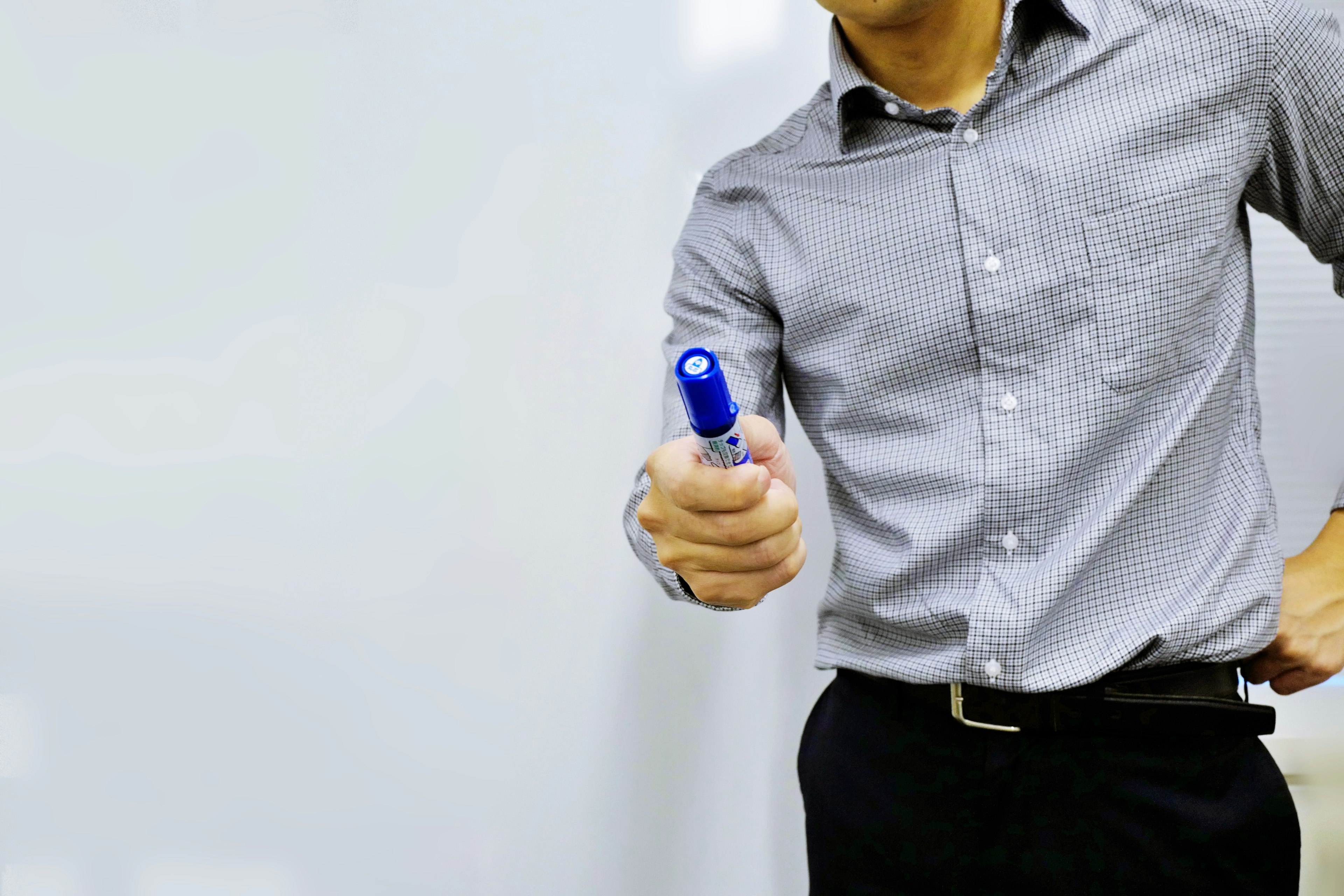 Man holding a blue marker in a business setting