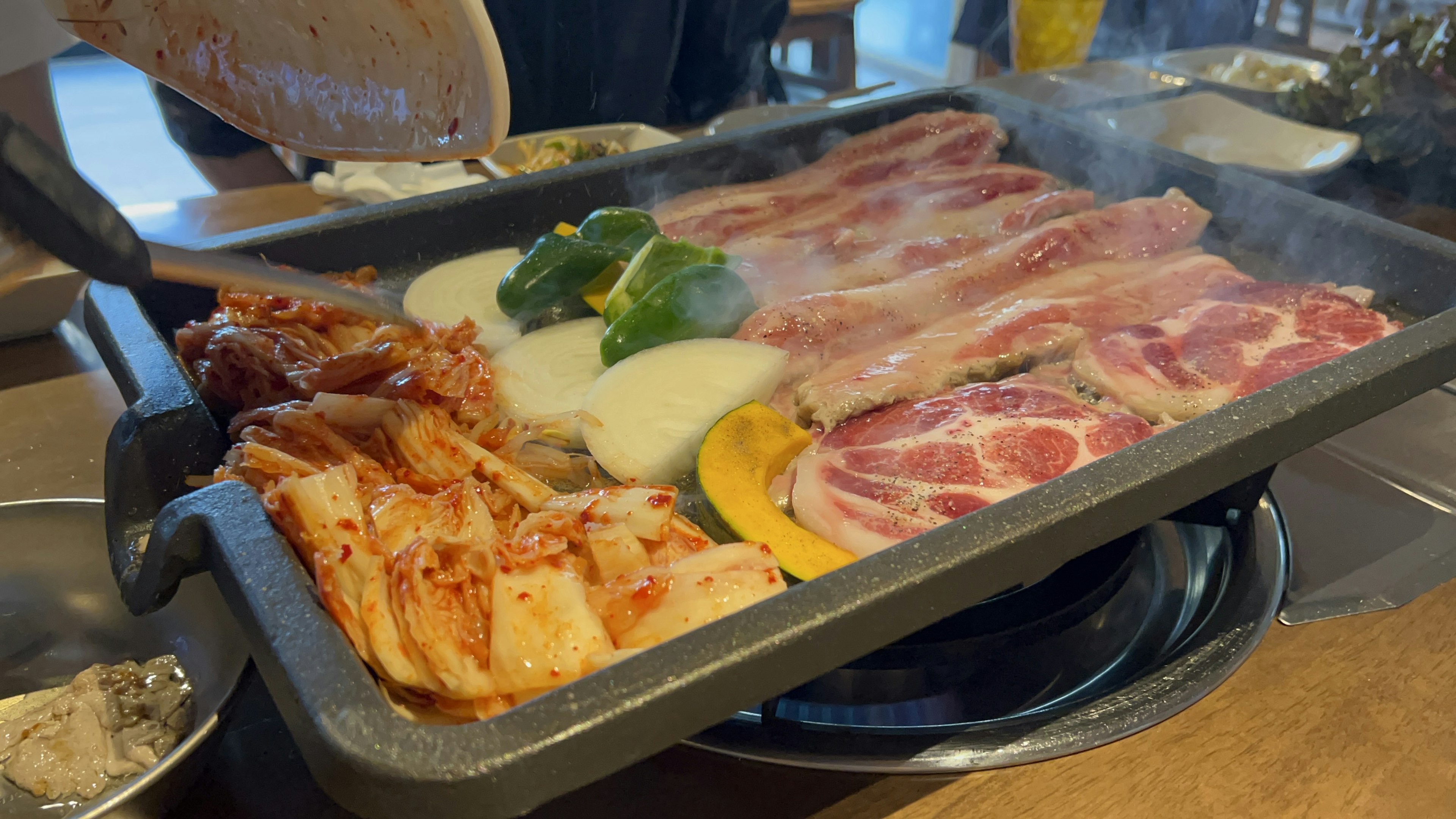 Grilled meat and vegetables arranged on a hot plate