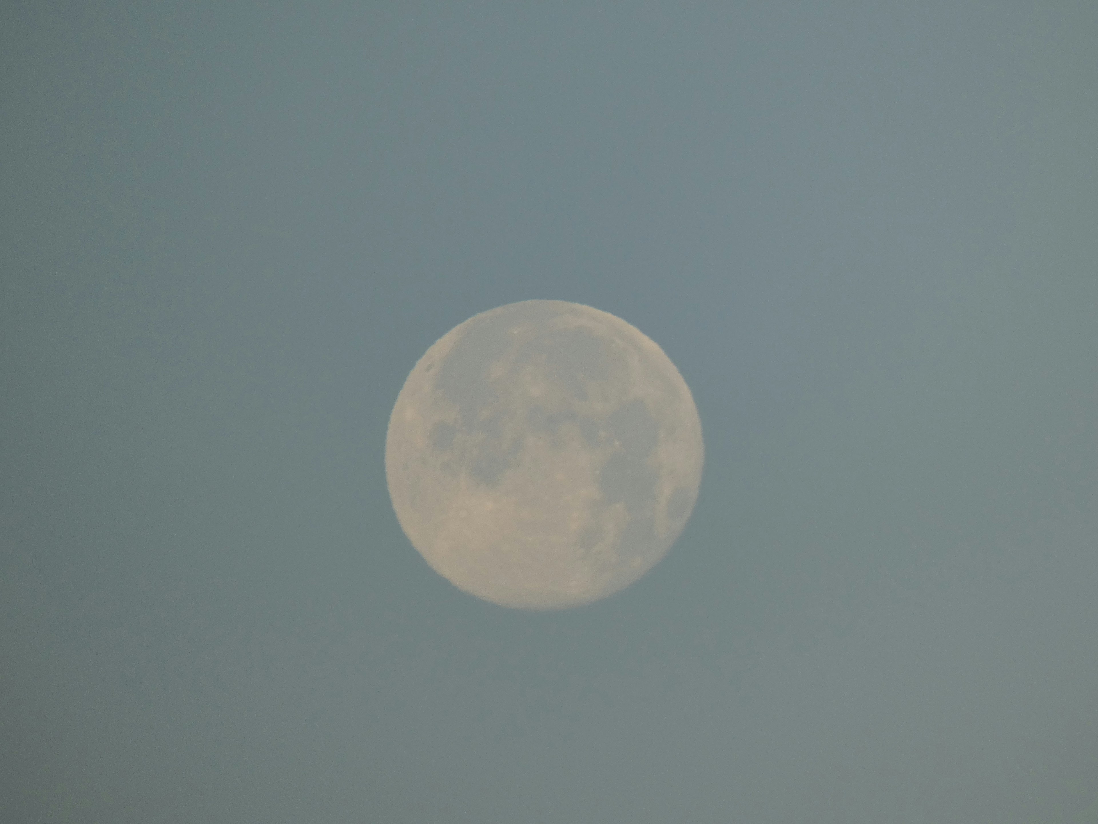 Nahaufnahme des hellen Vollmonds vor blauem Himmel