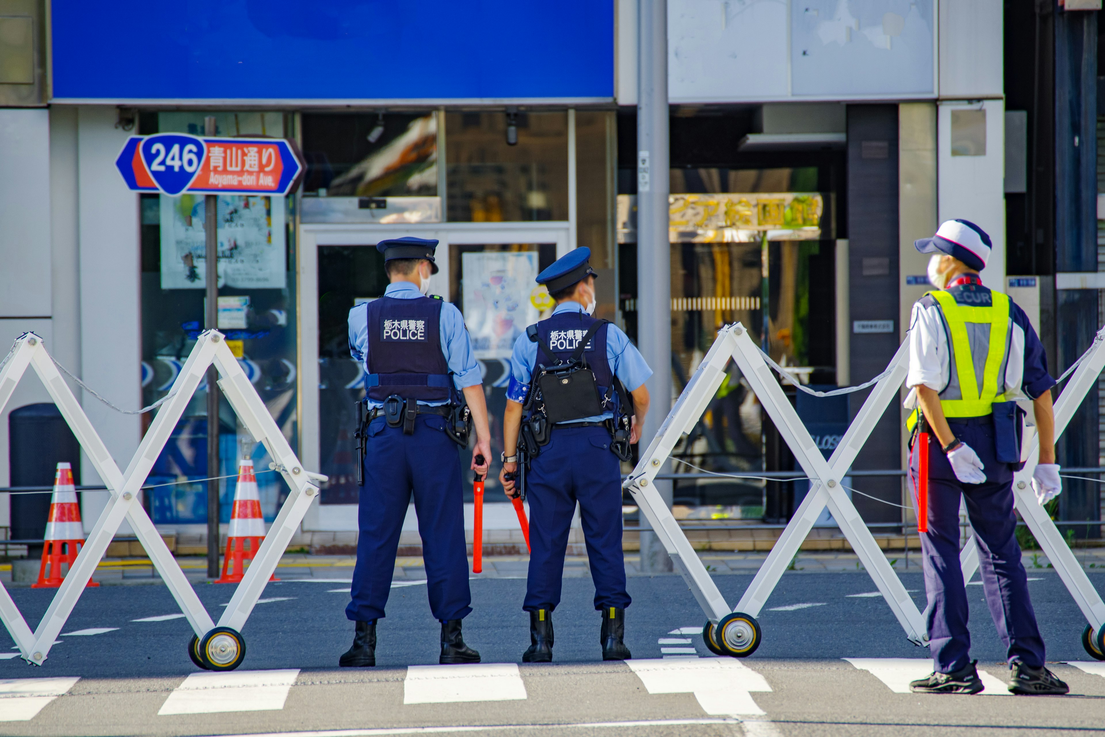 Police officers standing in front of barricades blocking a street entrance