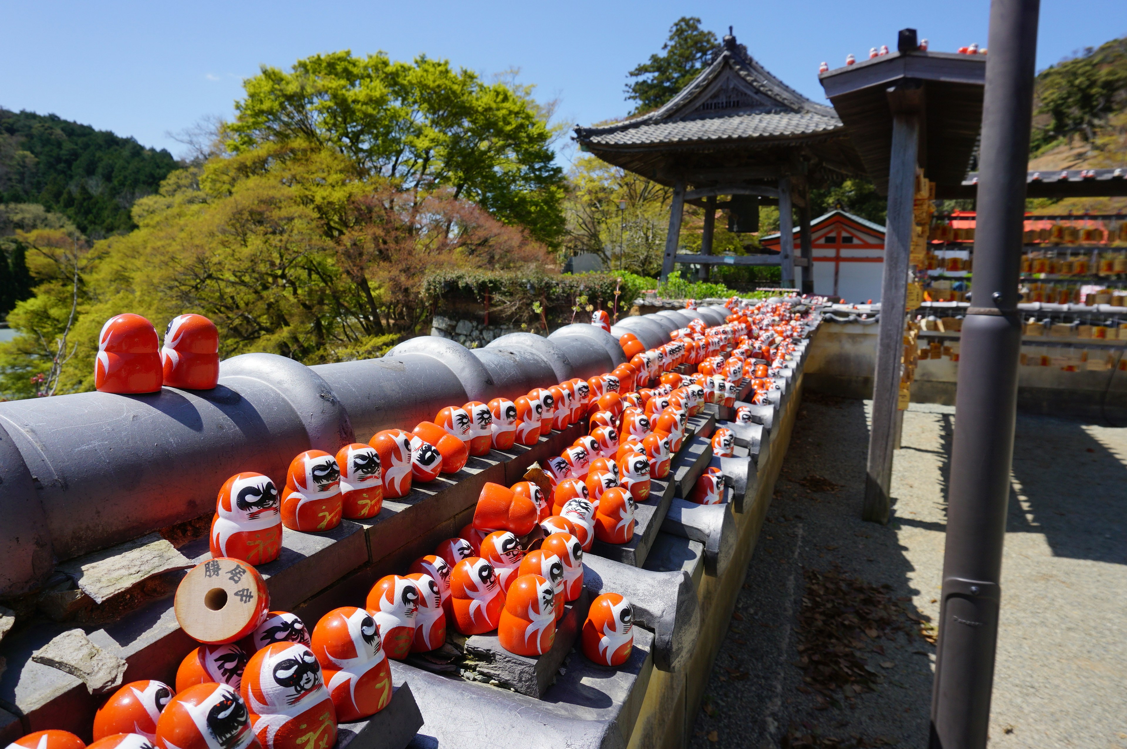 Scenic view of a temple courtyard filled with red daruma dolls