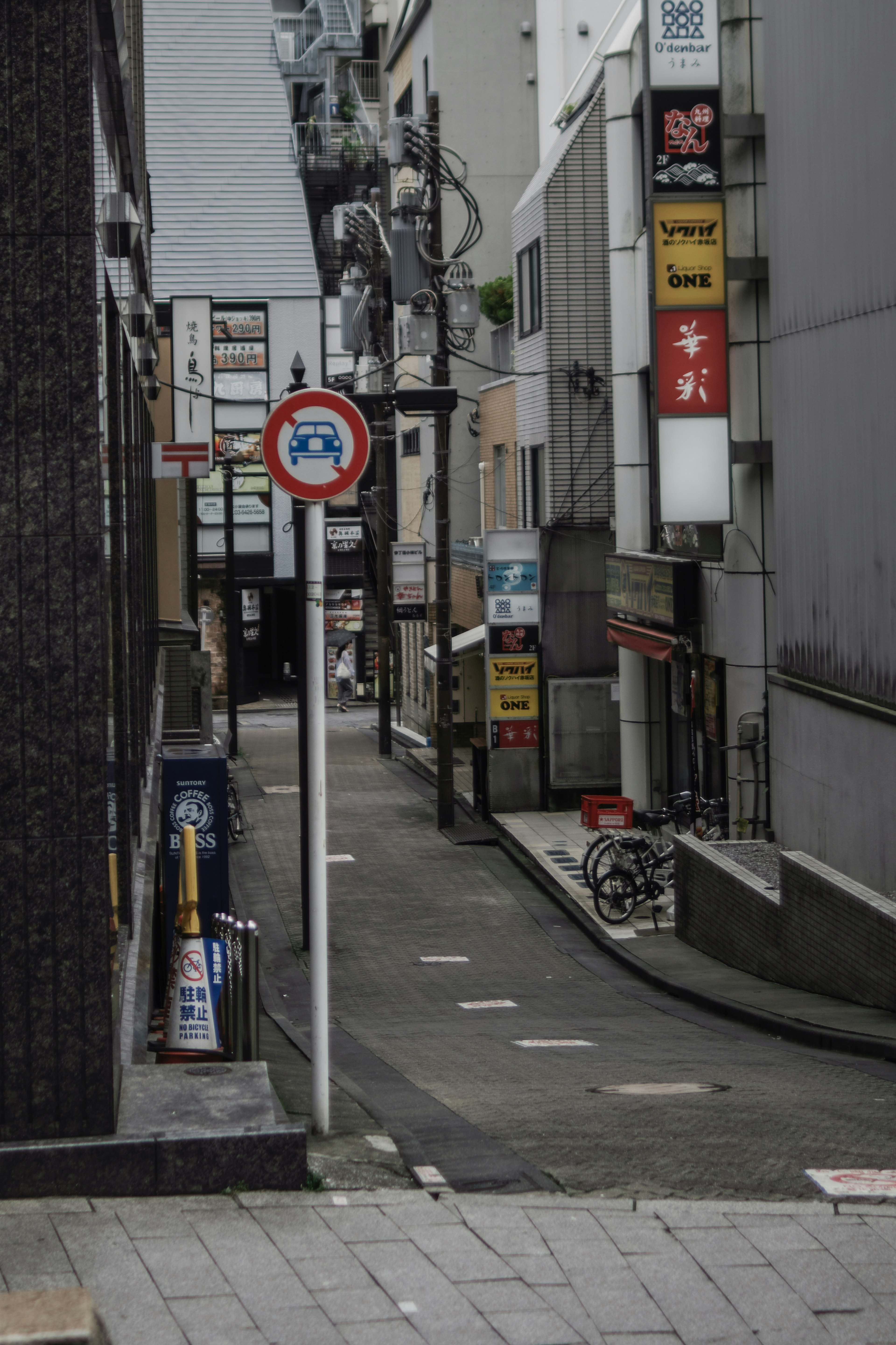 Narrow alley with a traffic sign and shop signs