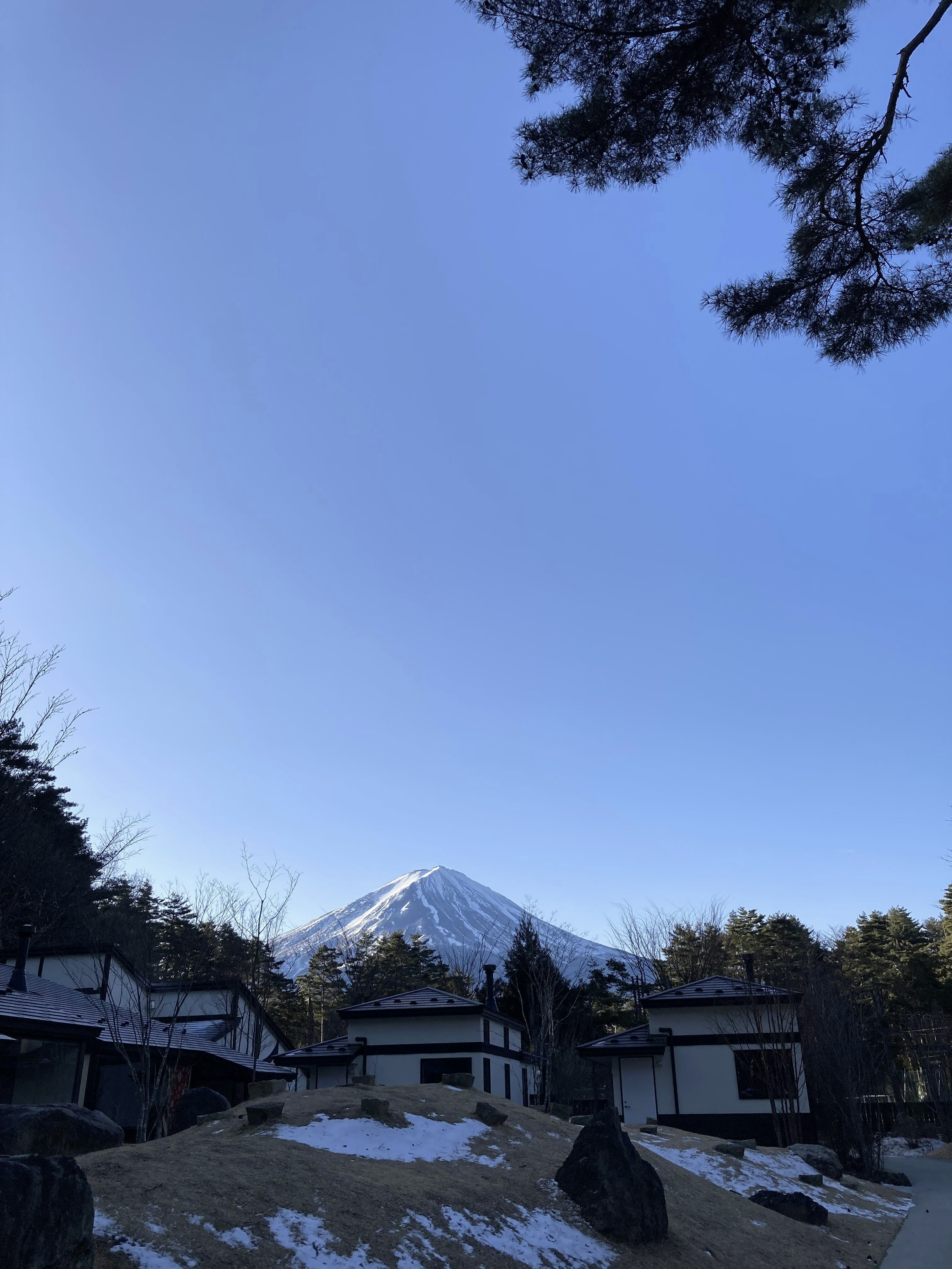 背景中有富士山和被雪覆蓋的土地的傳統日本房屋