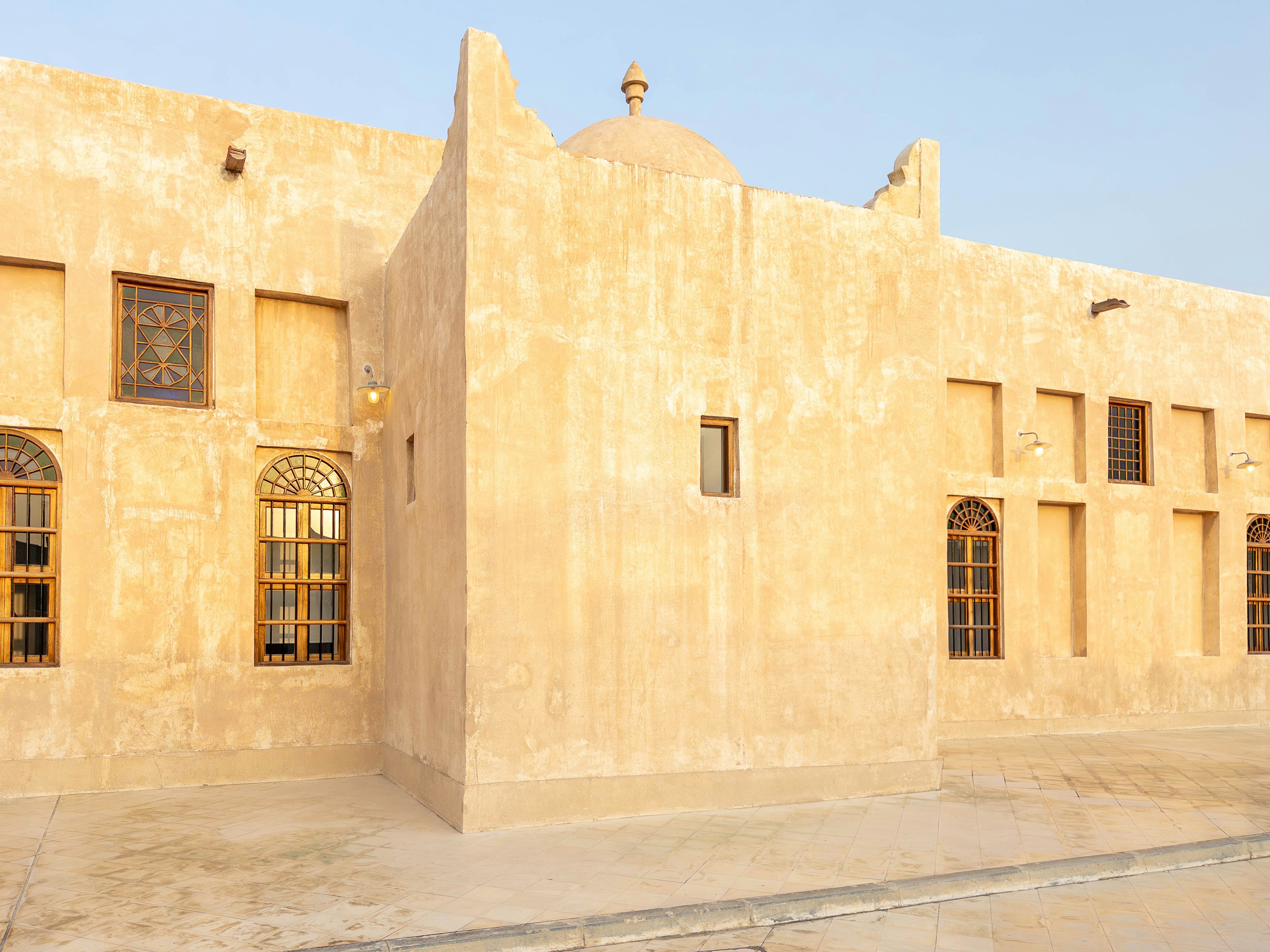 Exterior of a historic building with sand-colored walls and windows