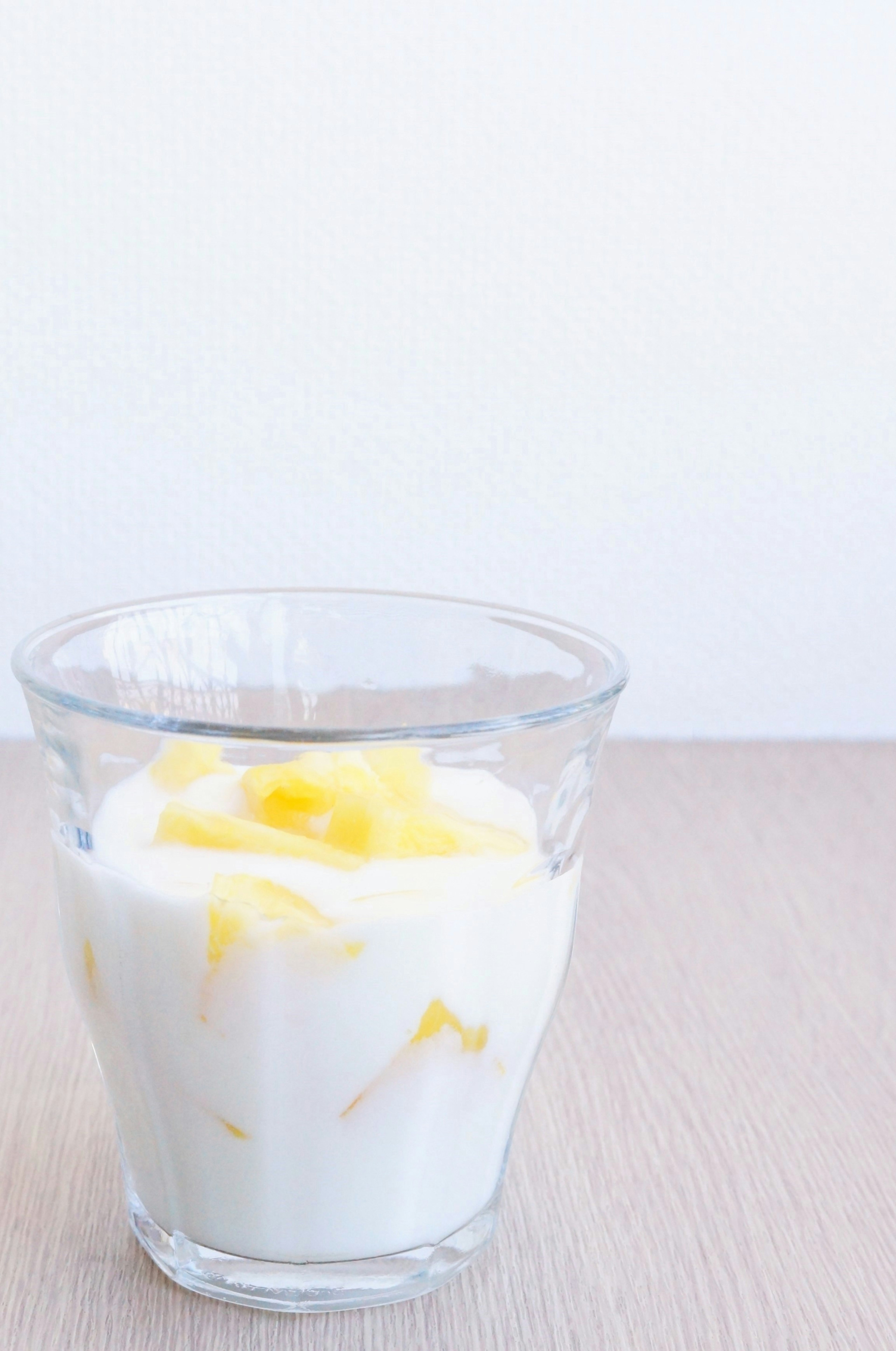 Un vaso de yogur con rodajas de mango en la parte superior