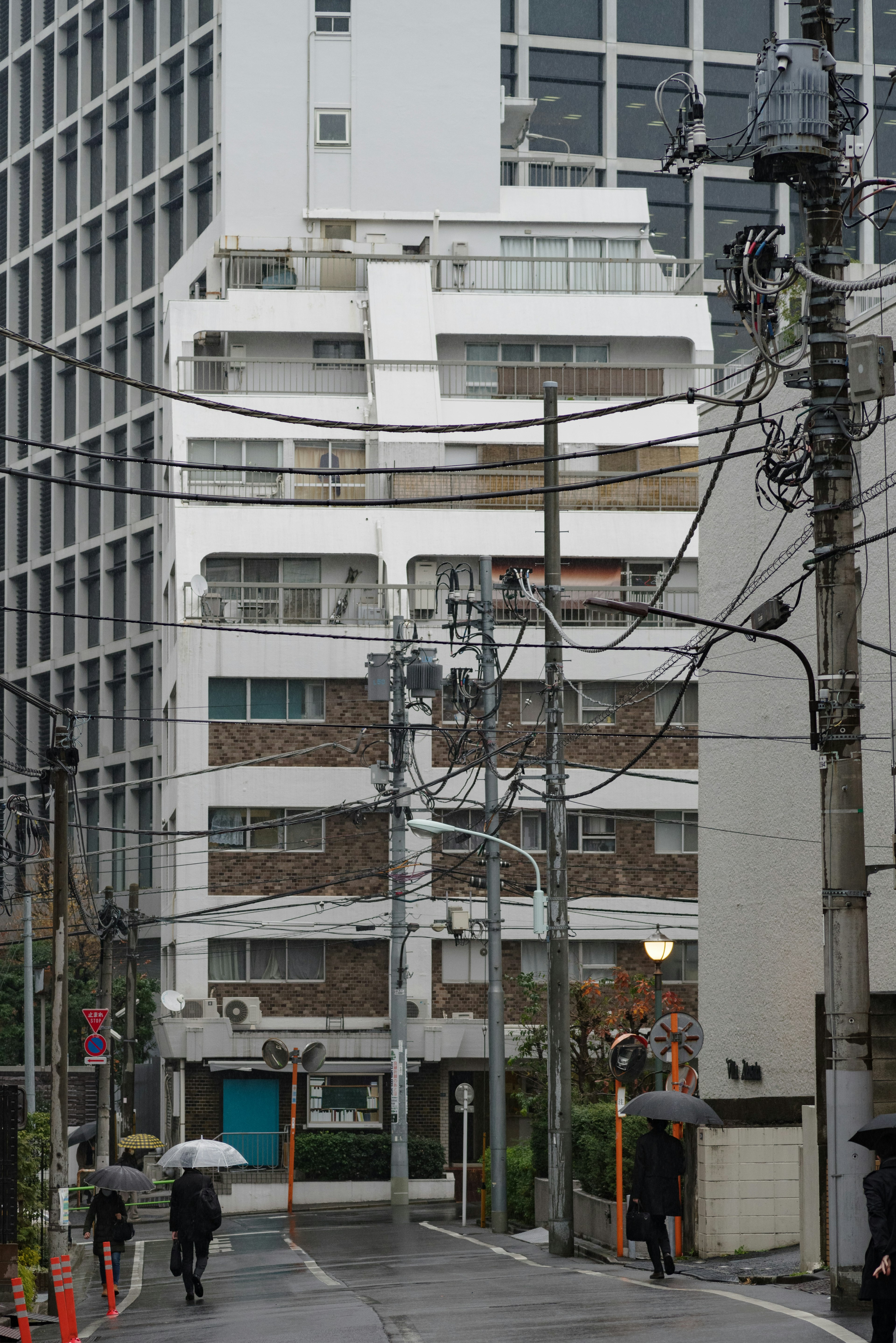 Scena urbana con persone che camminano sotto la pioggia e edifici moderni