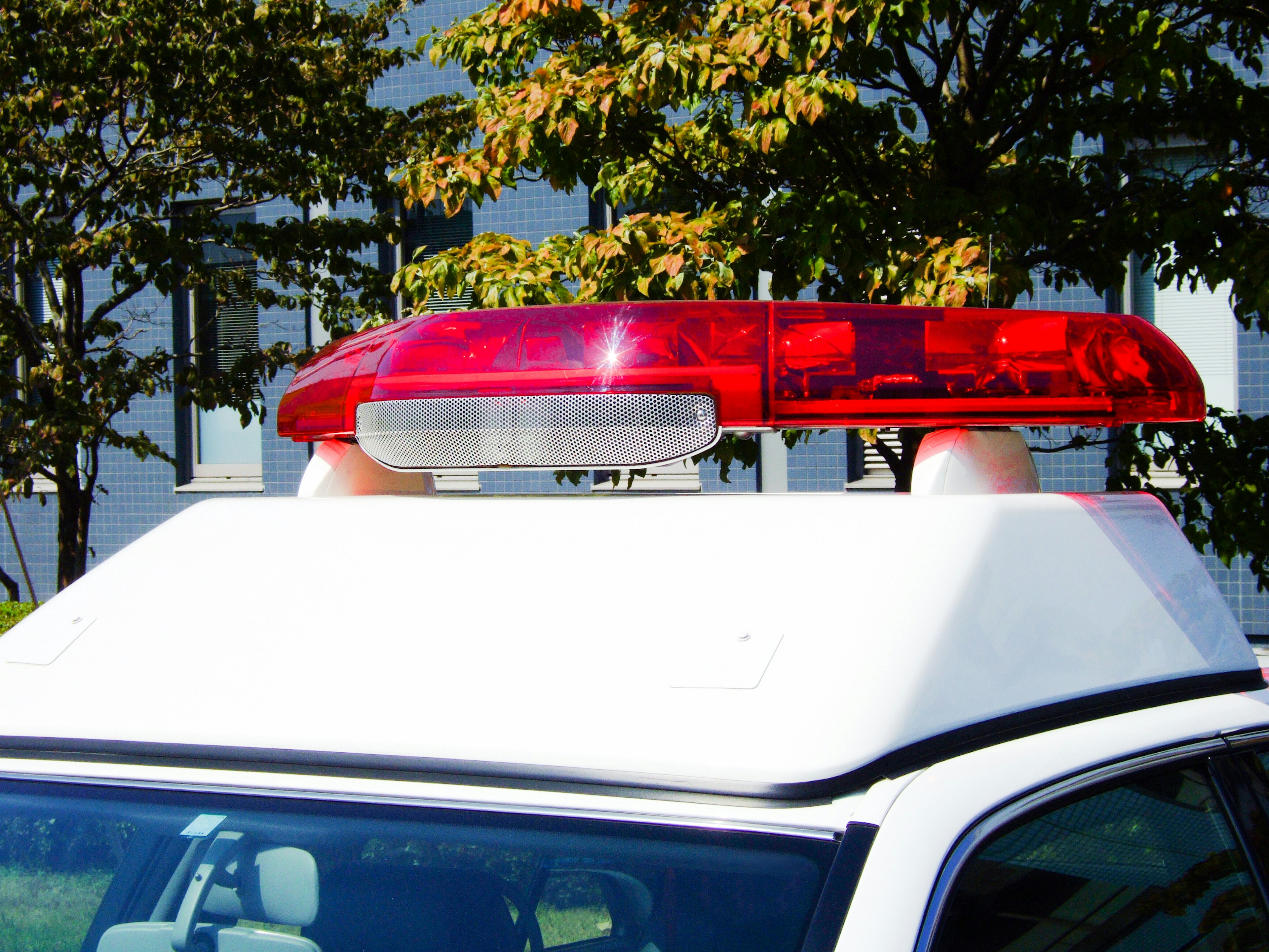 Red emergency light on top of a white vehicle