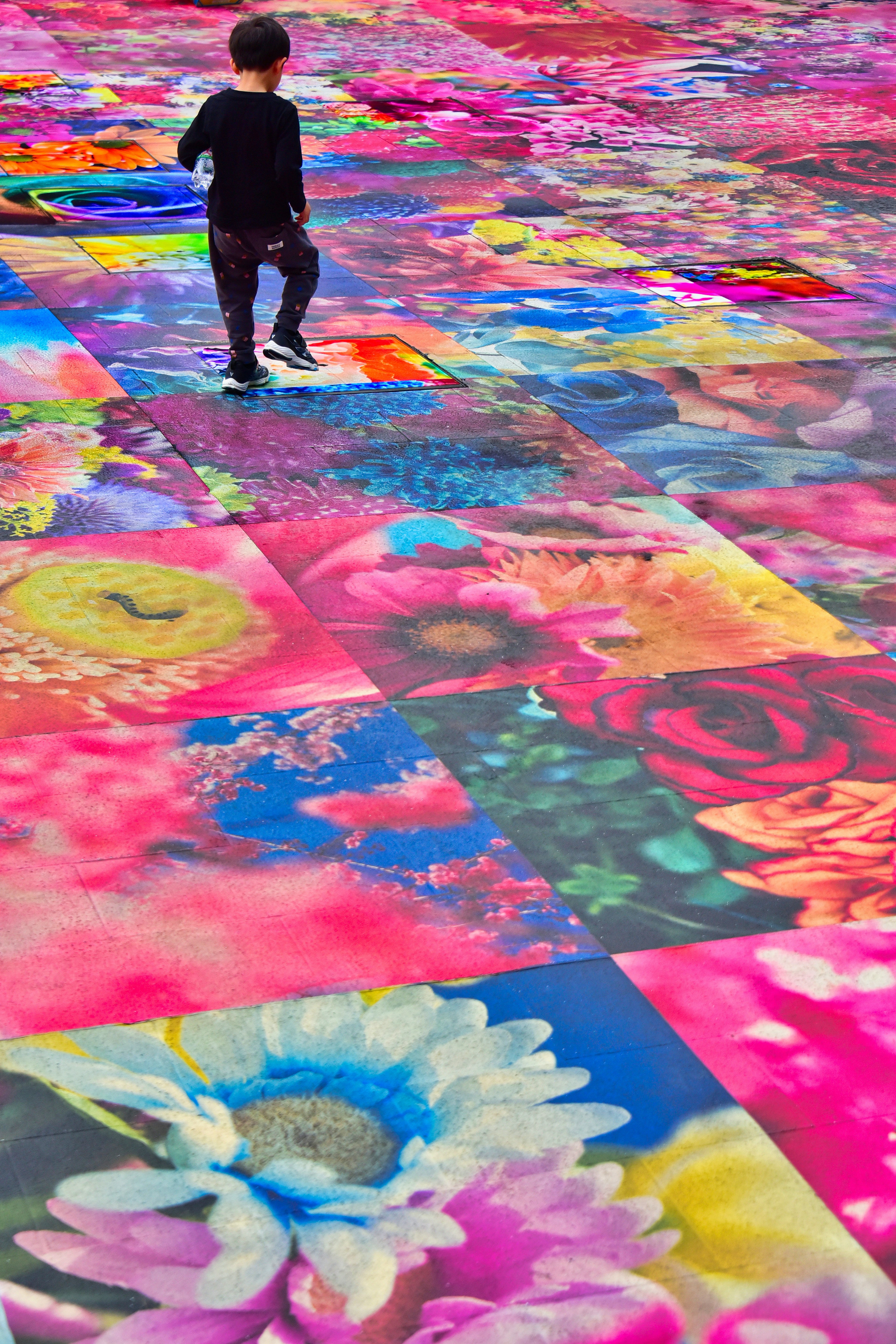 Child walking on colorful flower-patterned floor