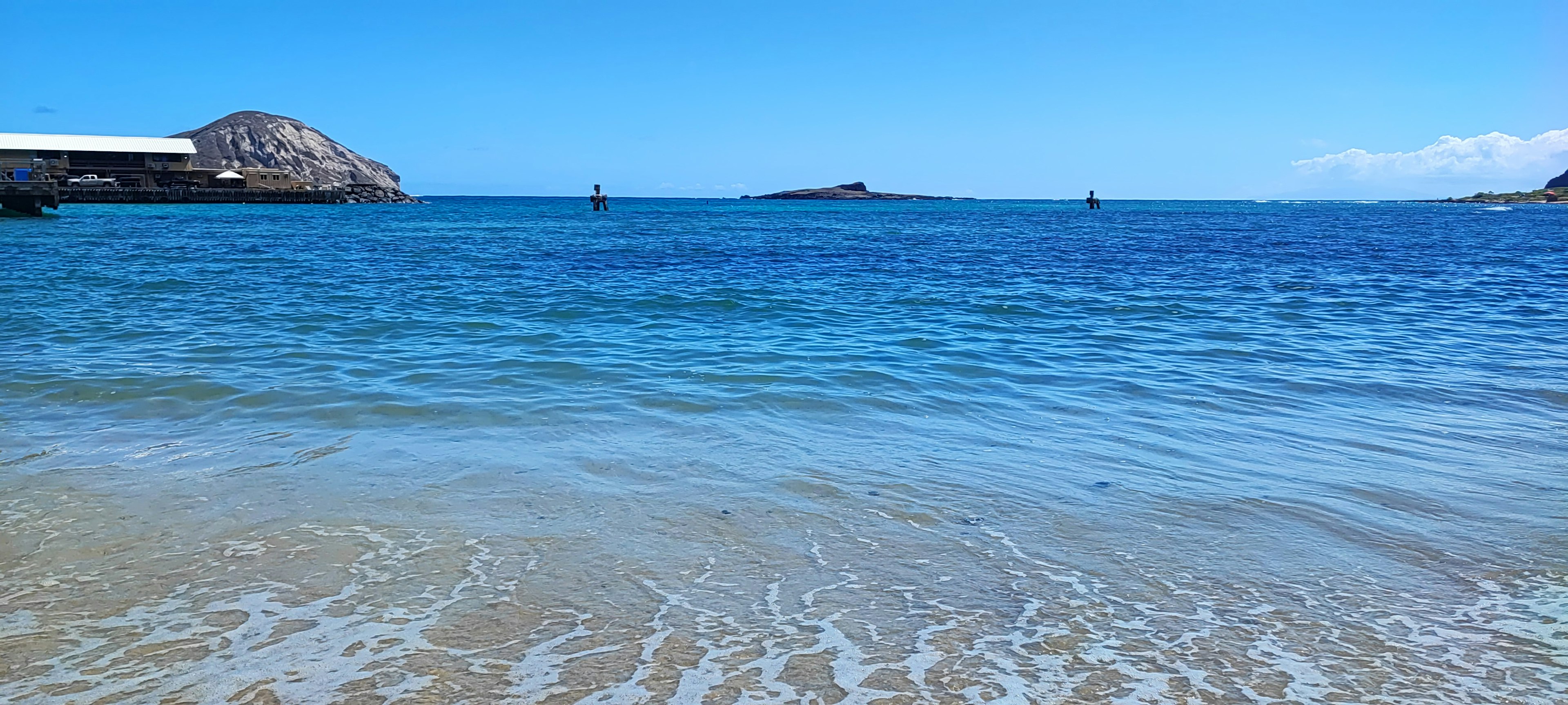 Pemandangan laut biru dan pantai berpasir tenang