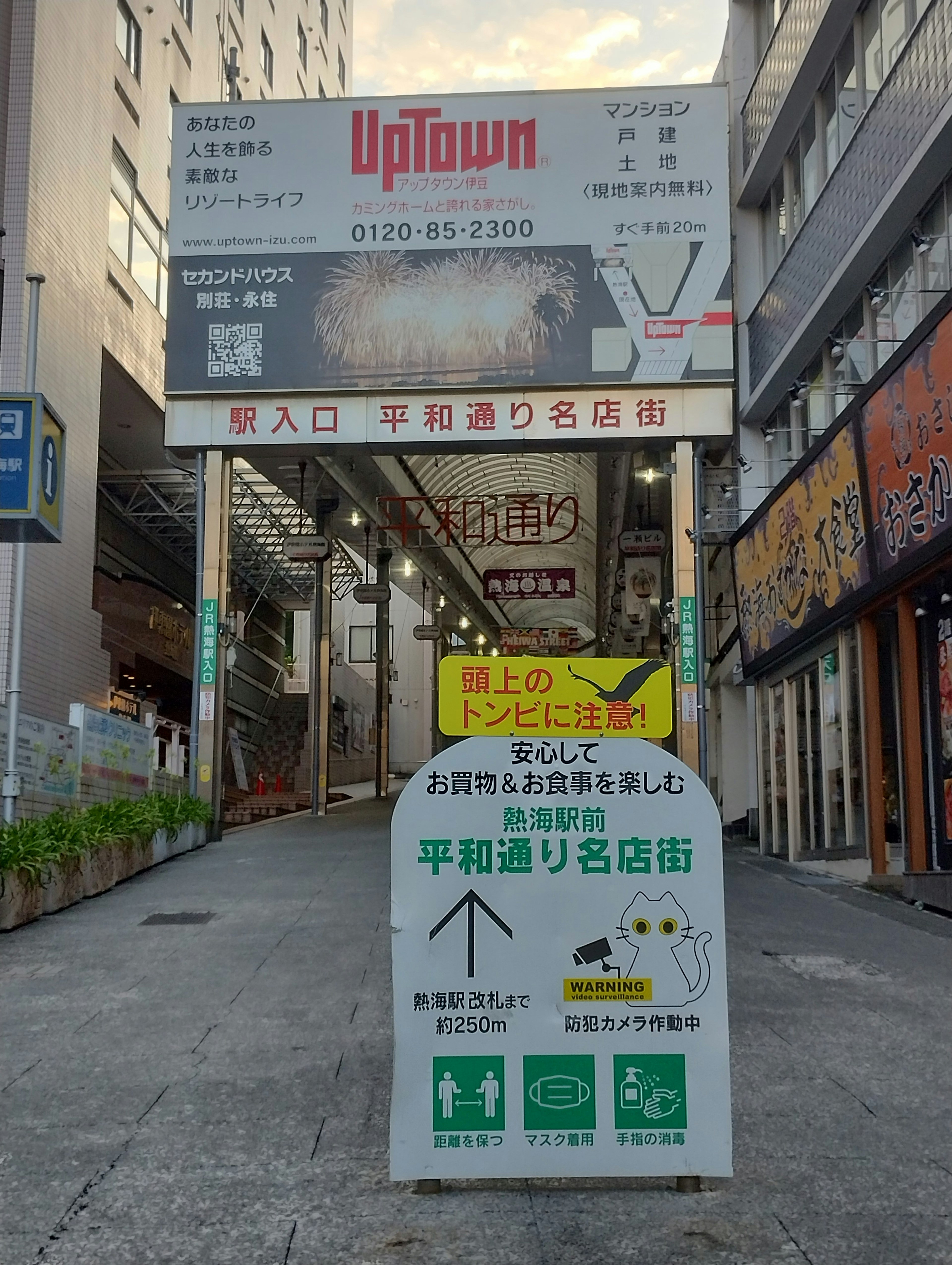 Rue commerciale avec des panneaux indiquant l'entrée de Uptown et des chemins piétonniers