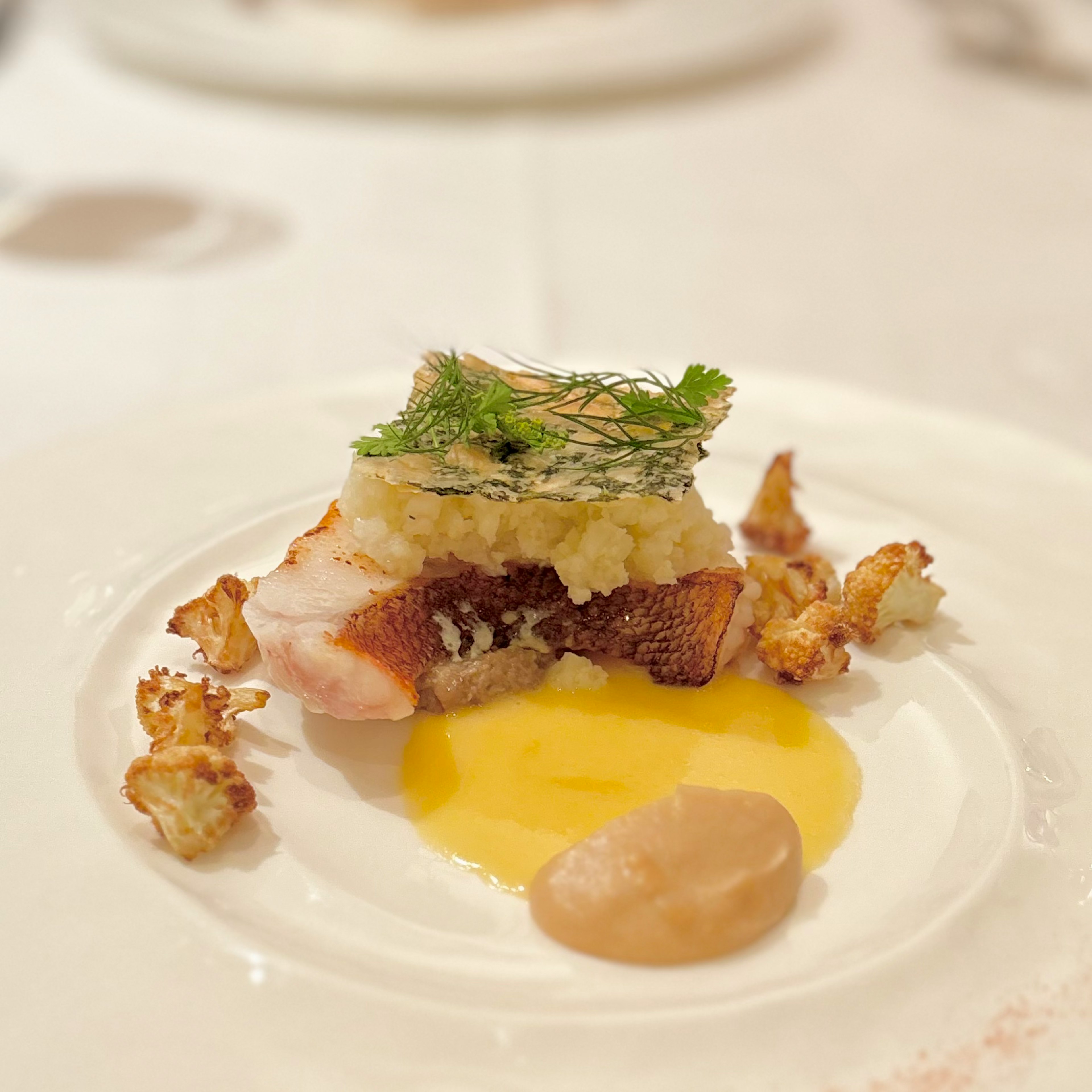 Plat élégant de poisson avec sauce crémeuse et garniture d'herbes accompagné de pop-corn