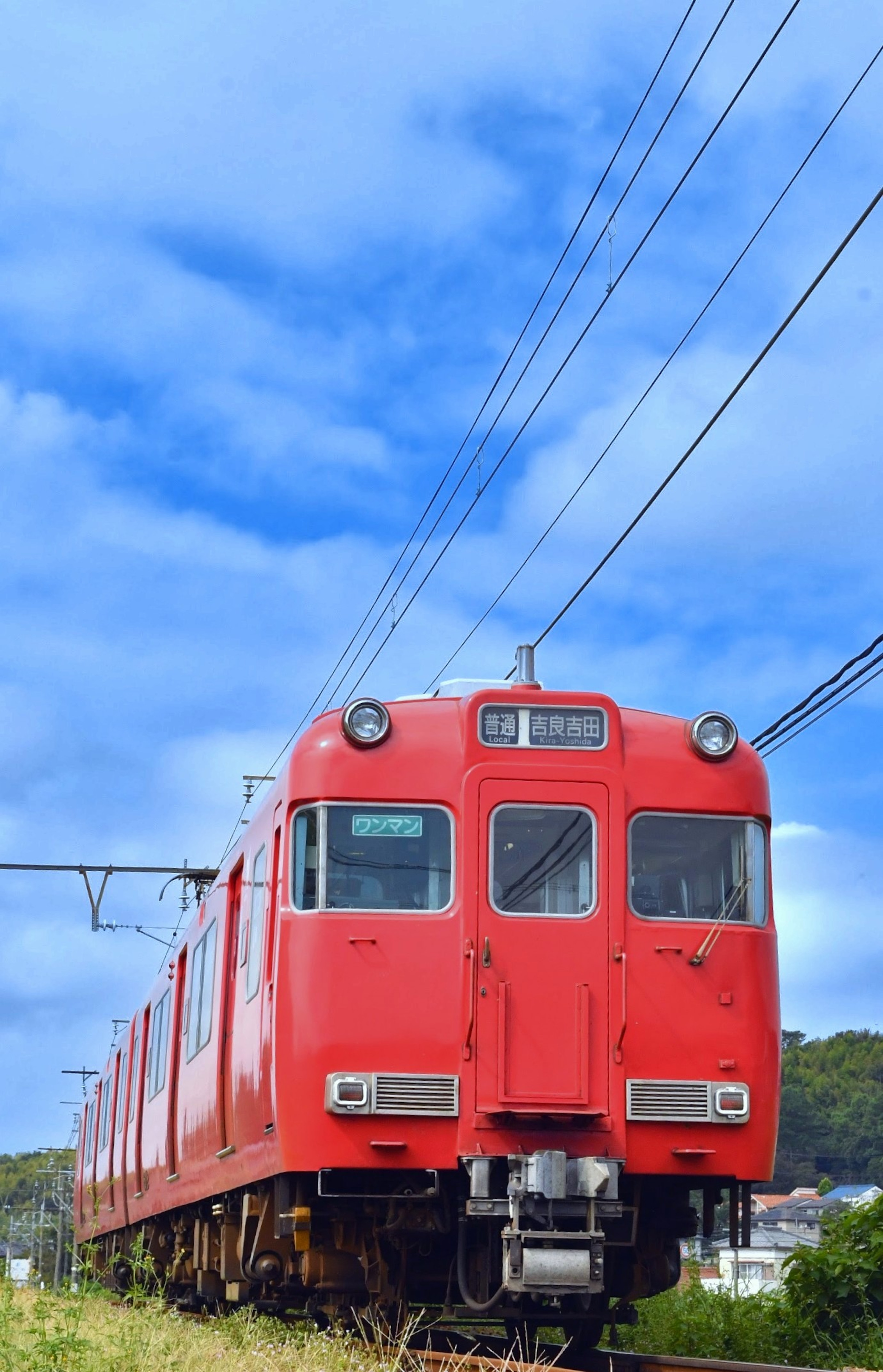 藍天之下的紅色火車在軌道上