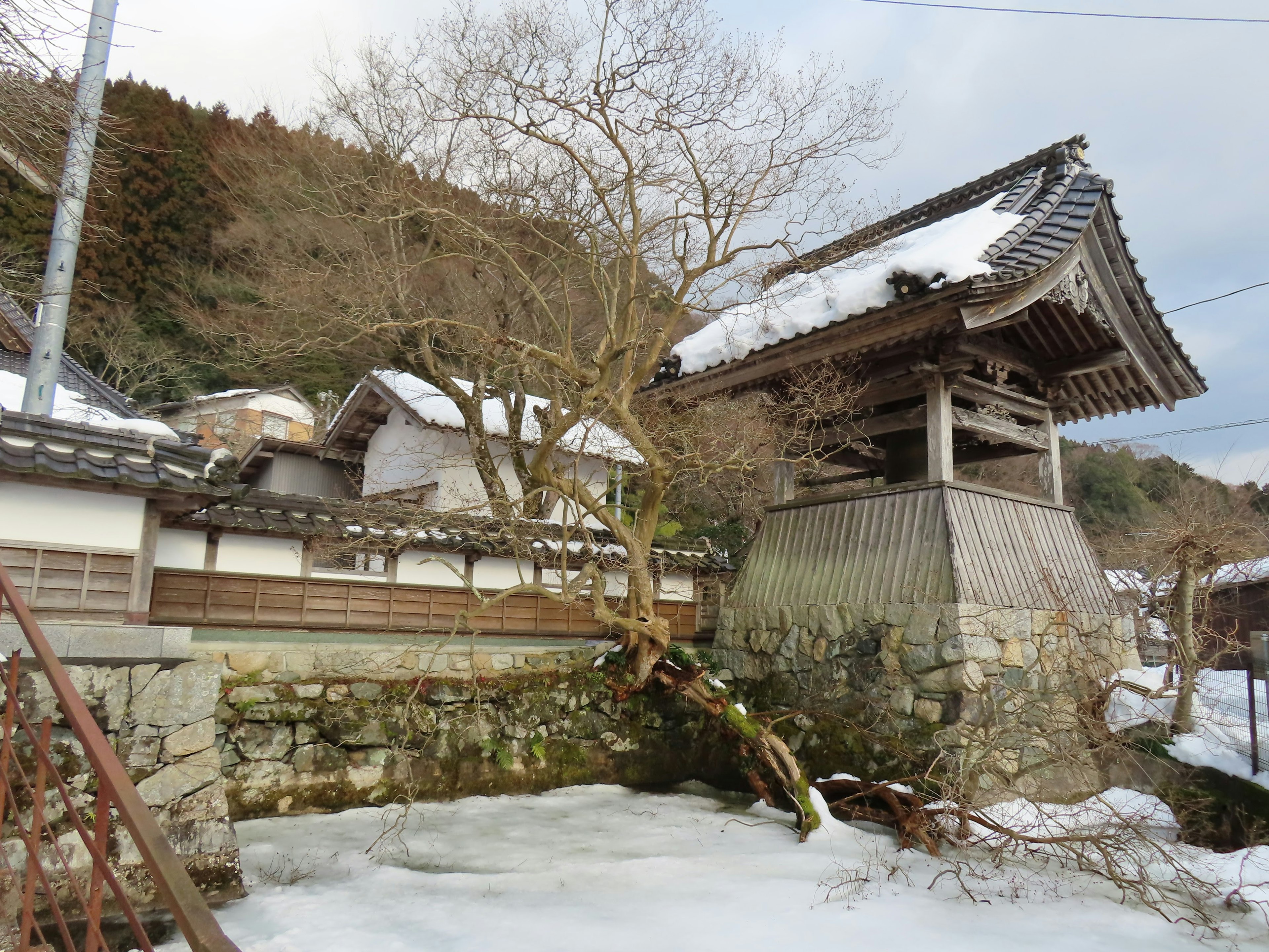 Edificios tradicionales japoneses y campanario cubiertos de nieve