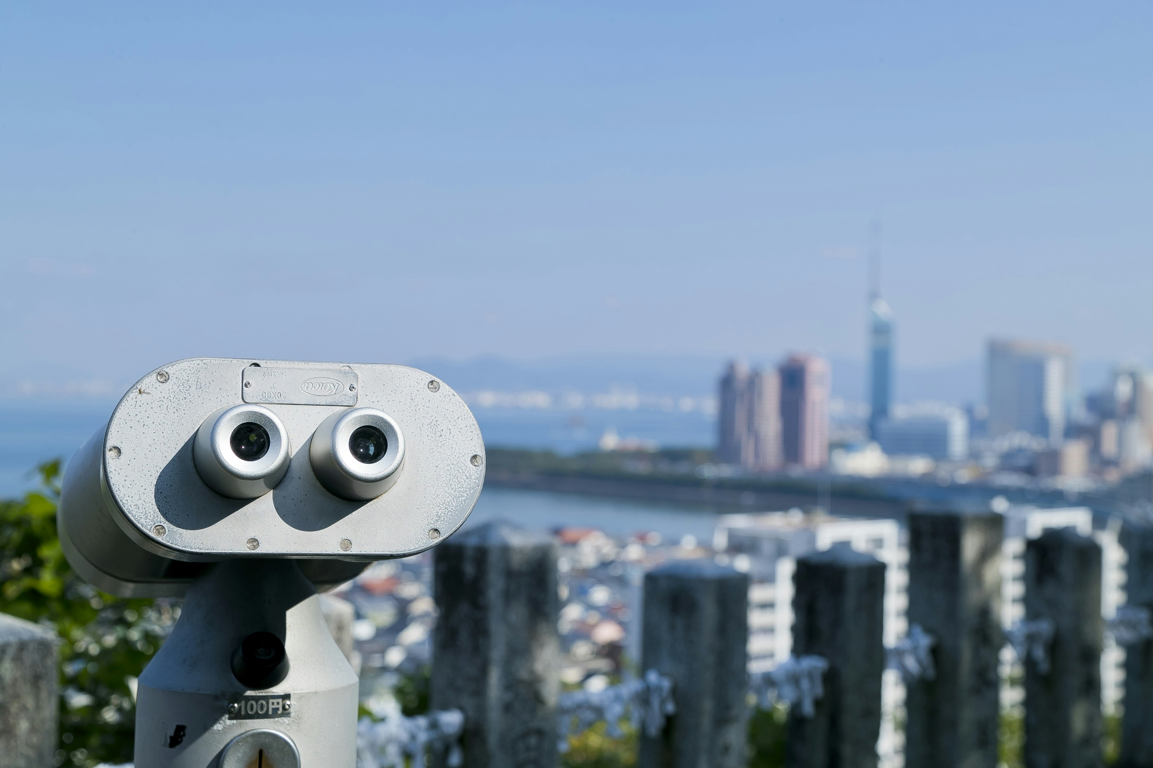 Binoculars in the foreground with a cityscape in the background